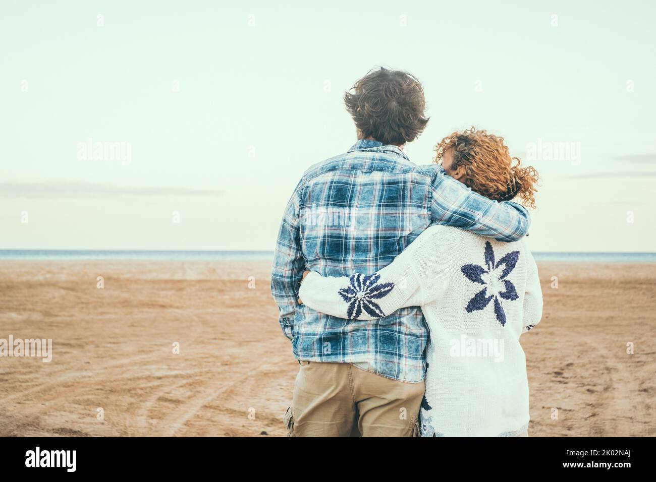 Rückansicht Porträt eines verliebten Paares, das den Strand und das Meer vor Liebe bewundert. Romantisches Leben im Winterurlaub. Menschen in Beziehung zu nehmen. Liebe und Zweisamkeit Konzept Stockfoto