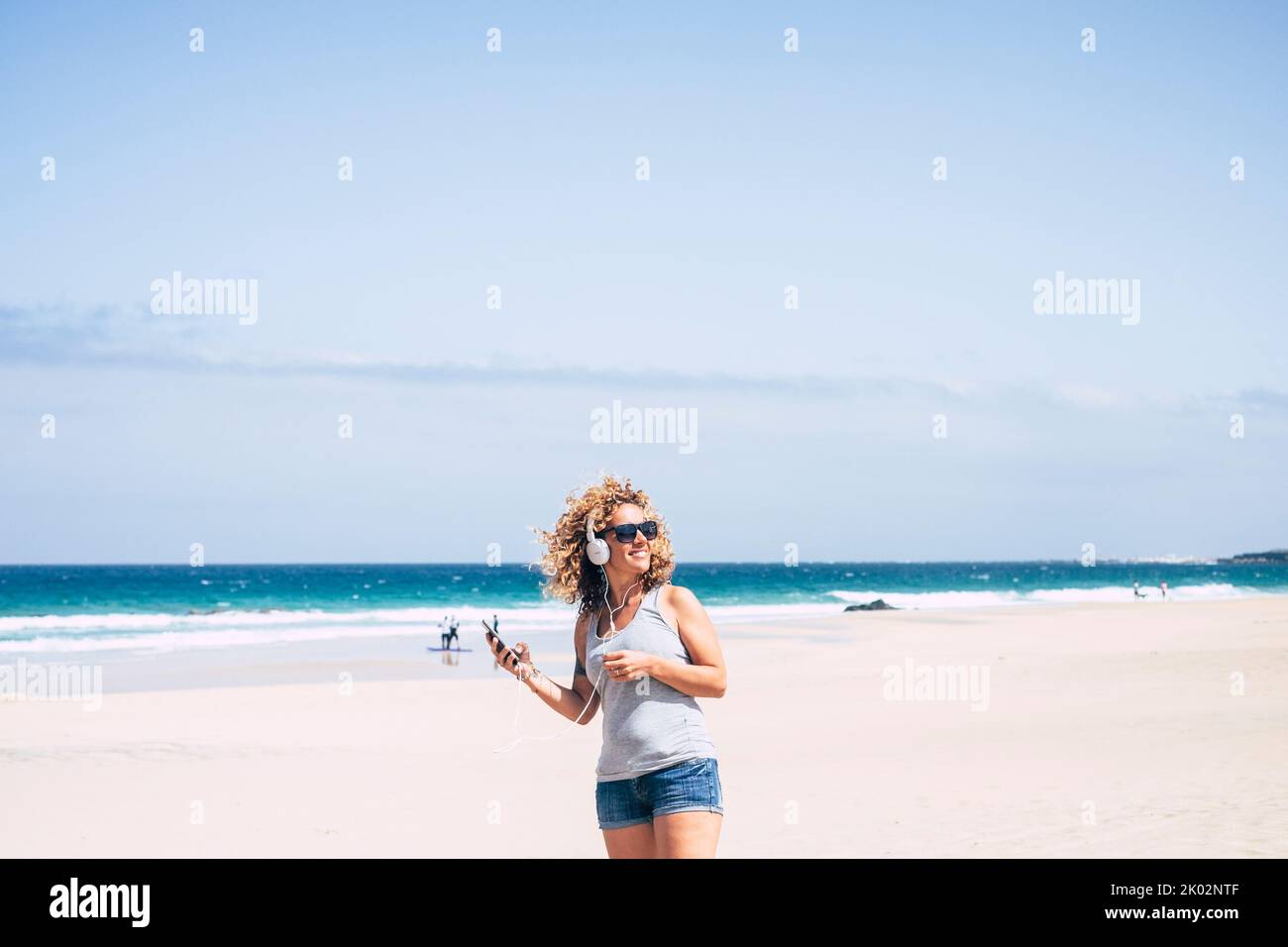 Glückliche weibliche Touristen Genießen Sie Freizeit im Freien am Strand Musik von Handy und Headset miling hören und genießen Sommerurlaub Reise Lebensstil. Fröhliche, hübsche Frau Stockfoto Glückliche weibliche Touristen Genießen Sie Freizeit im Freien am Strand Musik von Handy und Headset miling hören und genießen Sommerurlaub Reise Lebensstil. Fröhliche, hübsche Frau Stockfoto
