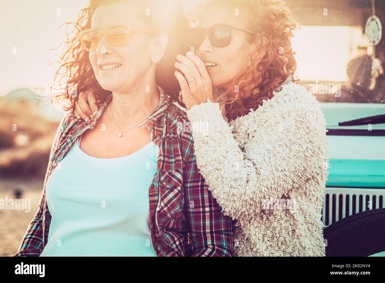Ein paar junge Erwachsene Frauen sprechen zusammen in Outdoor-Freizeitreisen Aktivität mit Sonne im Hintergrund. Konzept von Freundschaft und Liebe. Lifestyle für Reisende. Urlaub Touristischer im Sommer Stockfoto