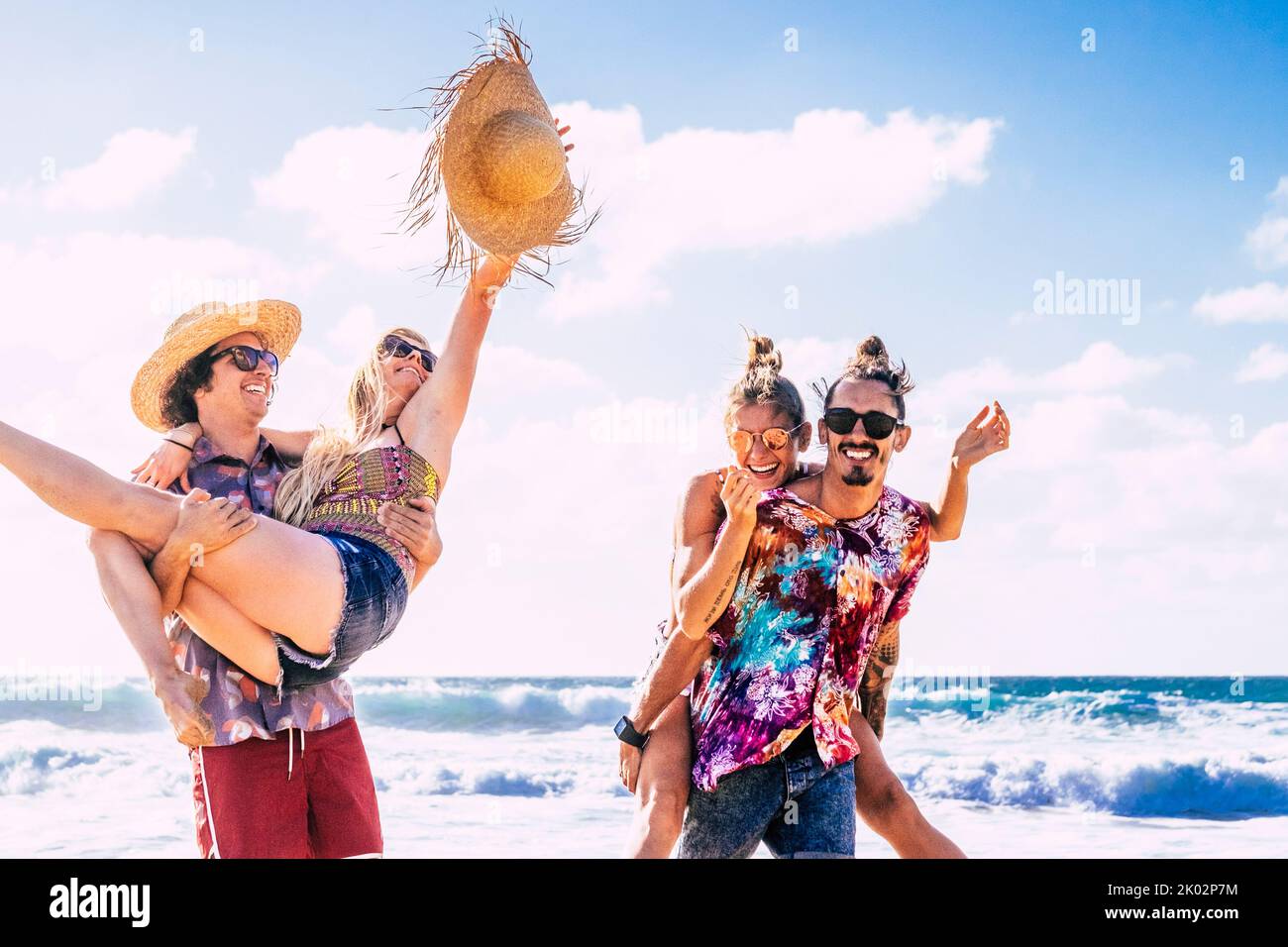 Gruppe von Freunden Touristen haben Spaß und spielen zusammen am Strand mit Meerwasser im Hintergrund. Fröhliche und glückliche Gruppe von Menschen in Outdoor-Freizeitaktivitäten im Sommerurlaub Urlaub Lebensstil Stockfoto