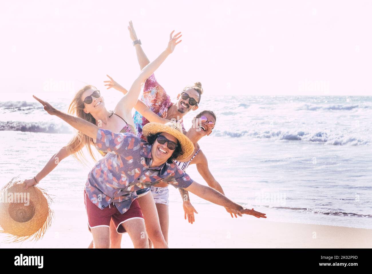 Gruppe von Freunden Touristen haben Spaß und spielen zusammen am Strand mit Meerwasser im Hintergrund. Fröhliche und glückliche Gruppe von Menschen in Outdoor-Freizeitaktivitäten im Sommerurlaub Urlaub Lebensstil Stockfoto