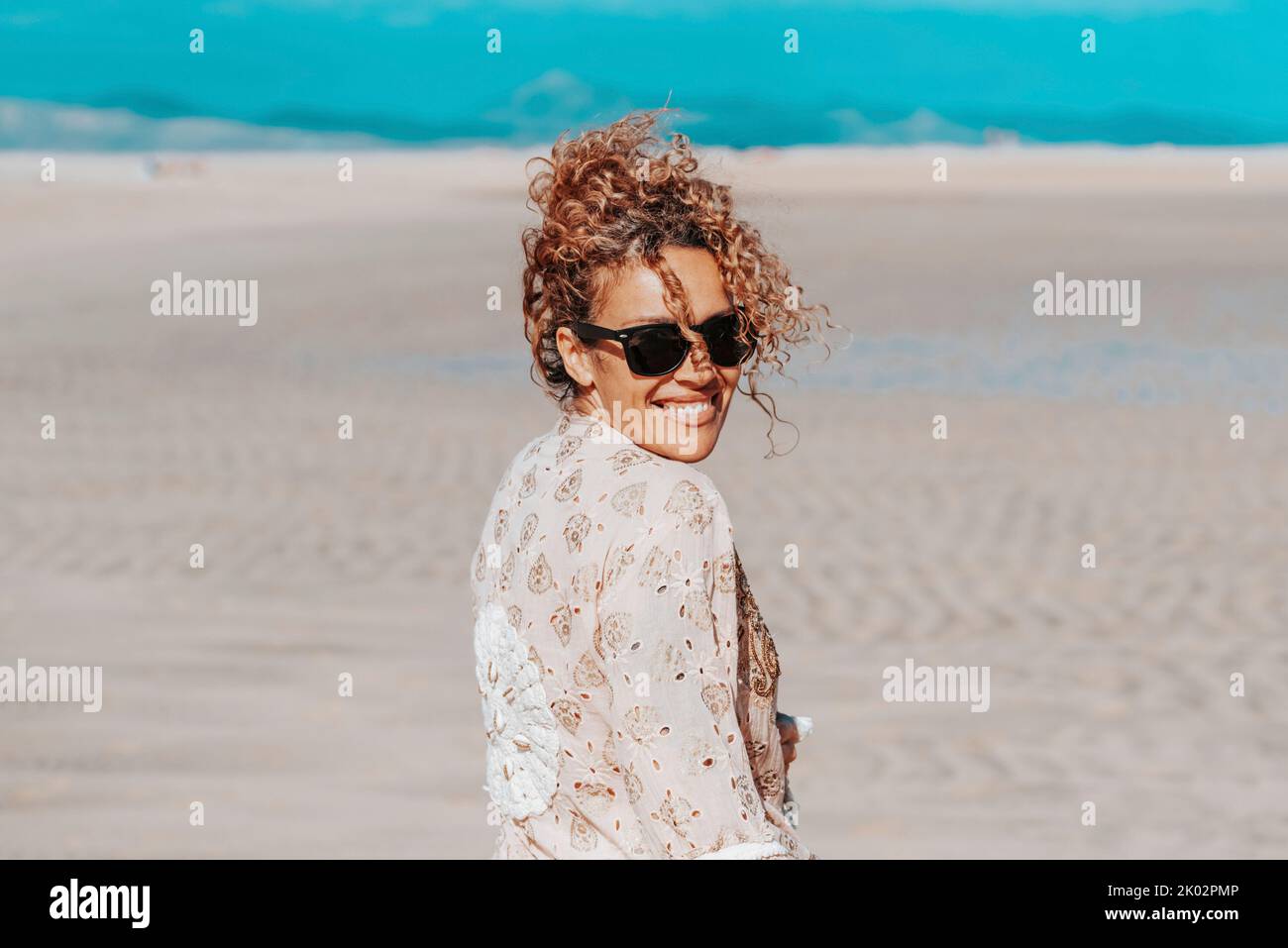Fröhliche weibliche Touristen genießen den Tag am Strand in den Sommerferien Blick auf die Kamera. Porträt einer erwachsenen Frau, die lächelt und Spaß an Freizeitaktivitäten im Freien hat. . Konzept des Glücks Stockfoto