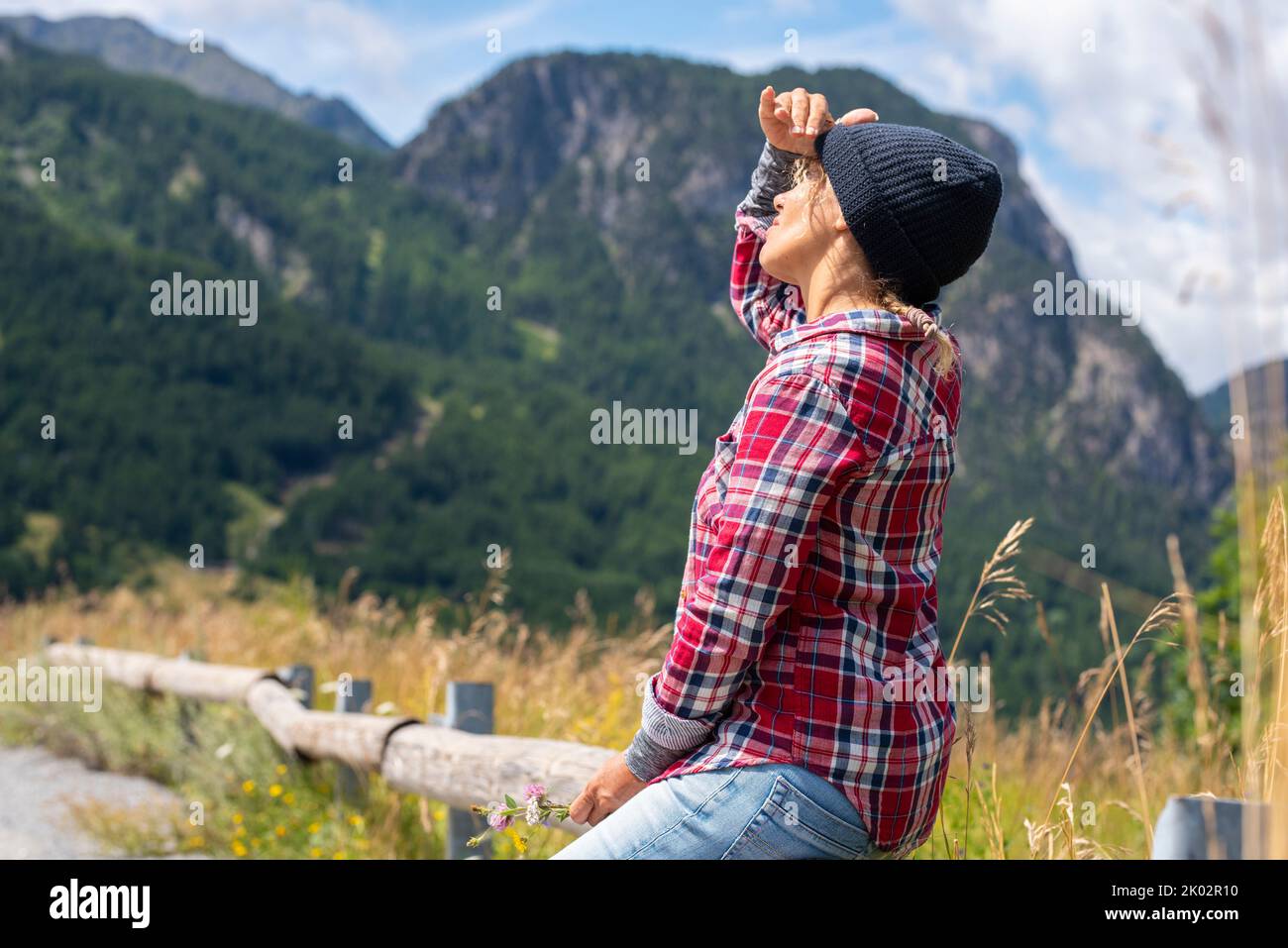 Outdoor-Freizeitangebot für Bergtouristen. Frau, die in den Himmel schaut. Tourismus und touristische Sommerferien. Freiheit und Aktivität auf der Landseite Stockfoto