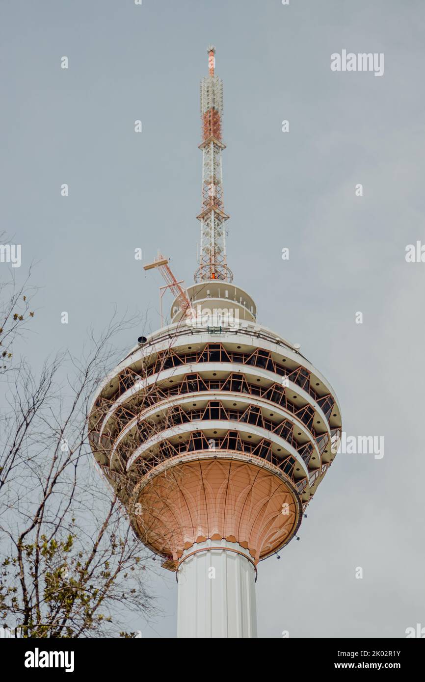Eine vertikale Aufnahme des wunderschönen Kuala Lumpur Turms gegen einen bewölkten Himmel in Malaysia Stockfoto