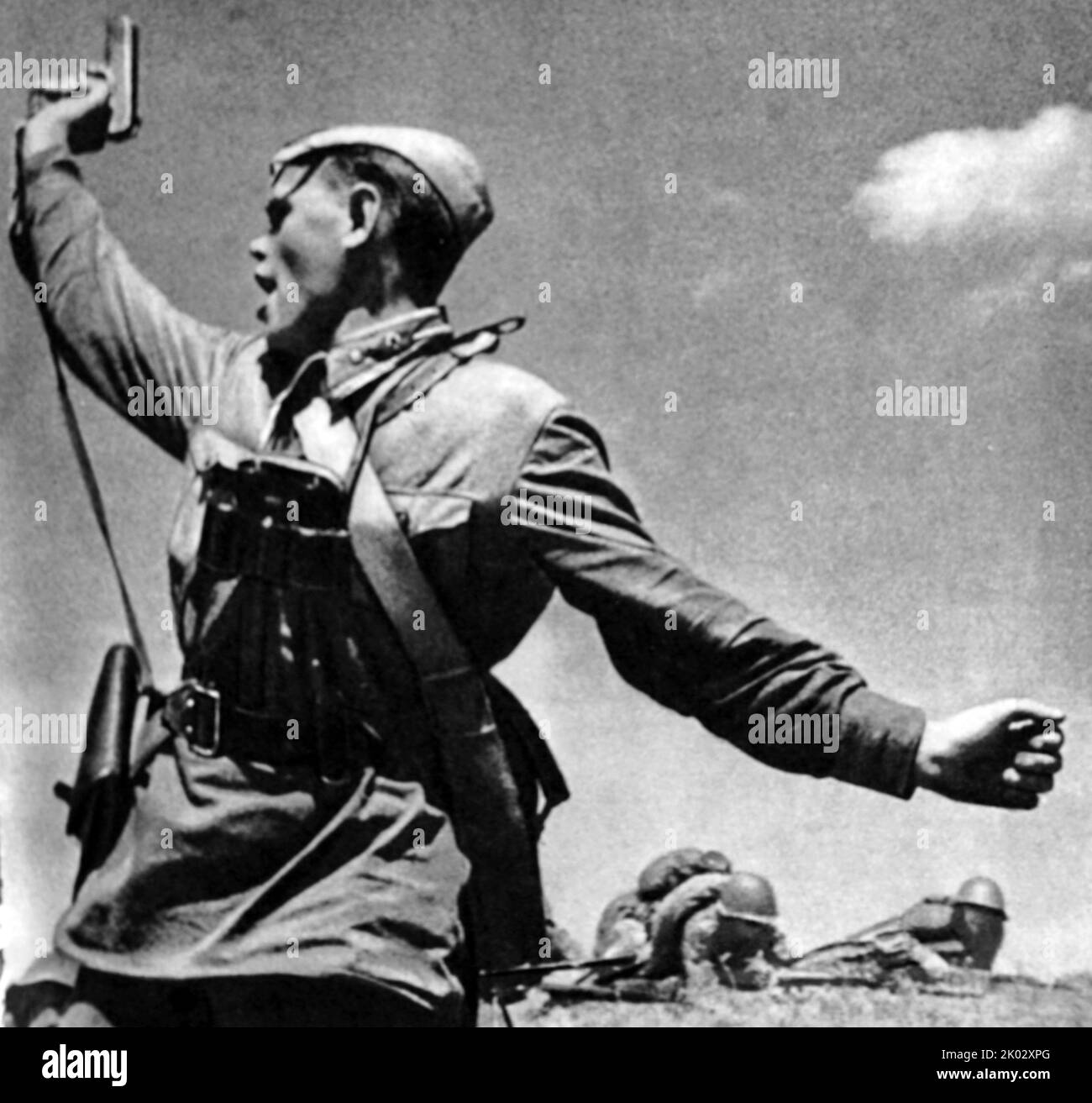 Kombat ist eine Schwarz-Weiß-Fotografie des sowjetischen Fotografen Max Alpert. Es zeigt einen sowjetischen Militäroffizier, der mit einer TT-Pistole bewaffnet ist und seine Einheit während des Zweiten Weltkriegs für einen Angriff aufhebt Dieses Werk gilt als eines der ikonischsten Fotografien aus dem Zweiten Weltkrieg, doch weder das Datum noch das Motiv sind mit Sicherheit bekannt. Das Foto zeigt den jungen Politruk Aleksei Jeryomenko, wenige Minuten vor seinem Tod am 12. Juli 1942, im Woroschilowgrad-Gebiet, Ukraine. Stockfoto