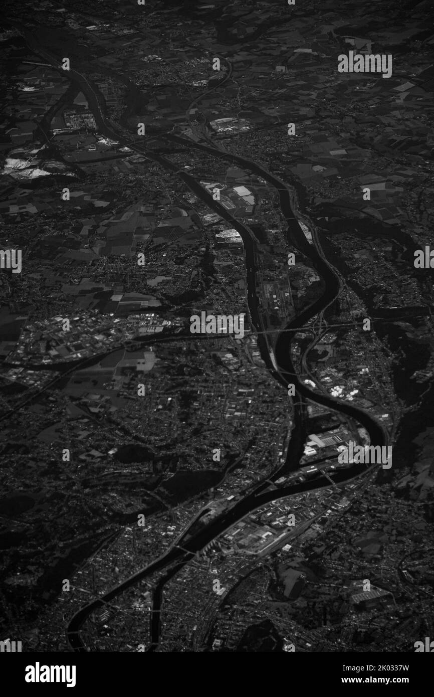 Eine Luftaufnahme einer Graustufenstadt mit Gebäuden, Feldern und flussudern Stockfoto