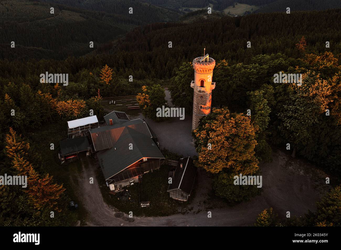 Deutschland, Thüringen, Ilmenau, erste Morgensonnenstrahlen erleuchten wie ein Scheinwerfer den Beobachtungsturm am Kickelhahn, Wald, Übersicht, Luftaufnahme Stockfoto