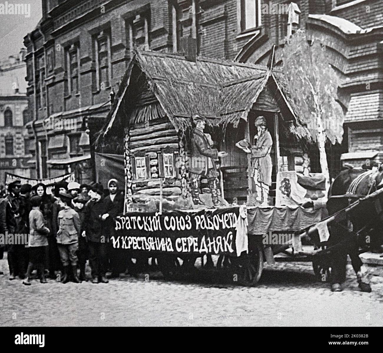 Agitationswagen mit einer Hütte zum Thema „Verbindung zwischen Stadt und Land“ bei einer Demonstration am 1. Mai 1919 in Moskau. Stockfoto