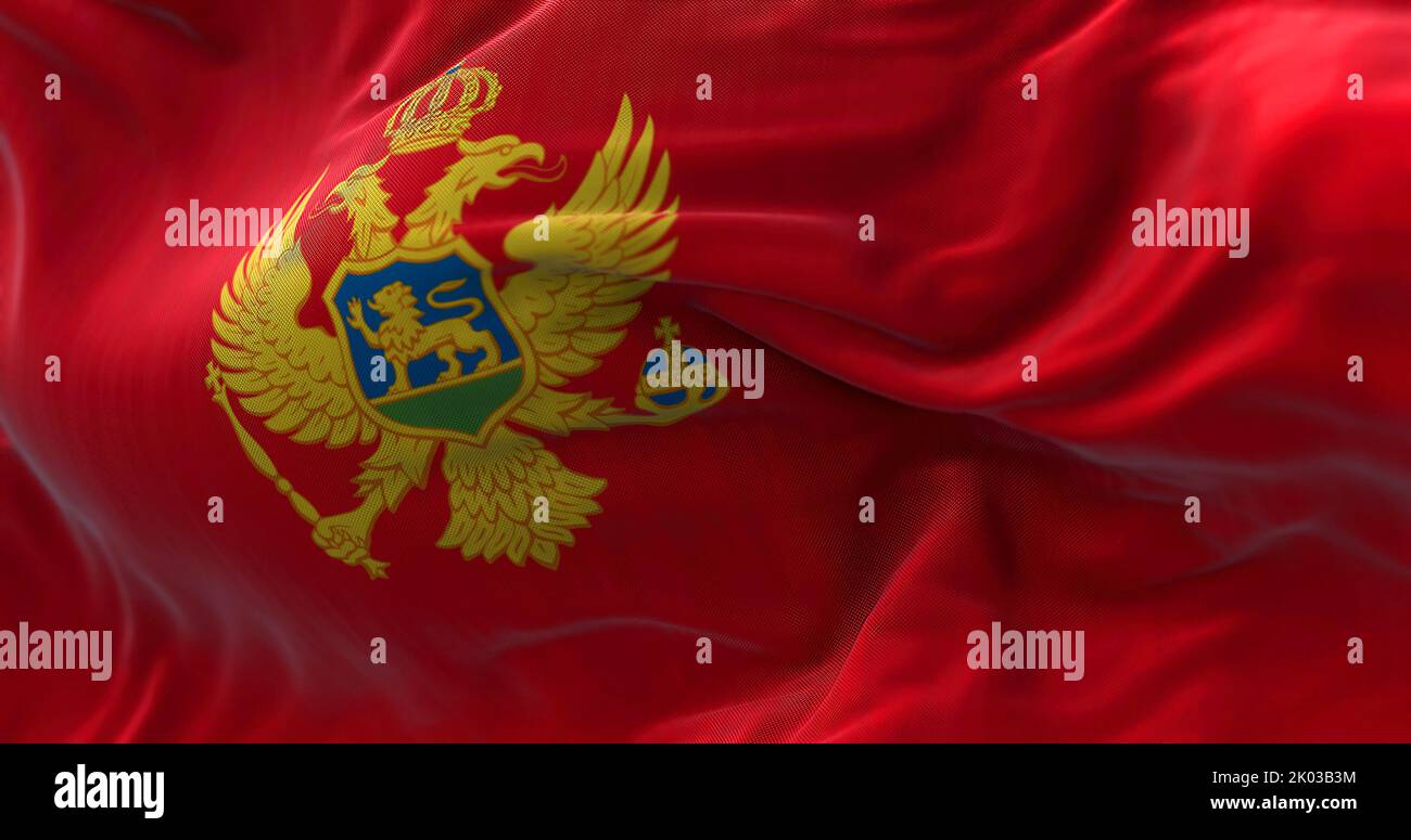 Nahaufnahme der im Wind winkenden Nationalflagge Montenegros. Montenegro ist ein Land in Südosteuropa. Texturierter Hintergrund aus Stoff. Selektiv Stockfoto