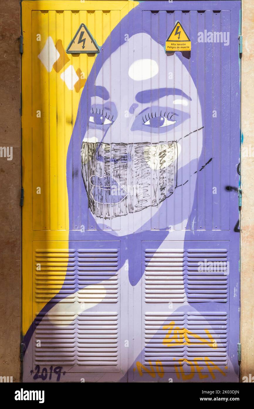 Spanien, Balearen, Mallorca, Palma de Mallorca. murales auf einem Umspannwerk mit einer Darstellung des Gesichts einer Frau, der in Zeiten von Covid / Pandemie / Covid-19 eine chirurgische Maske hinzugefügt wurde Stockfoto