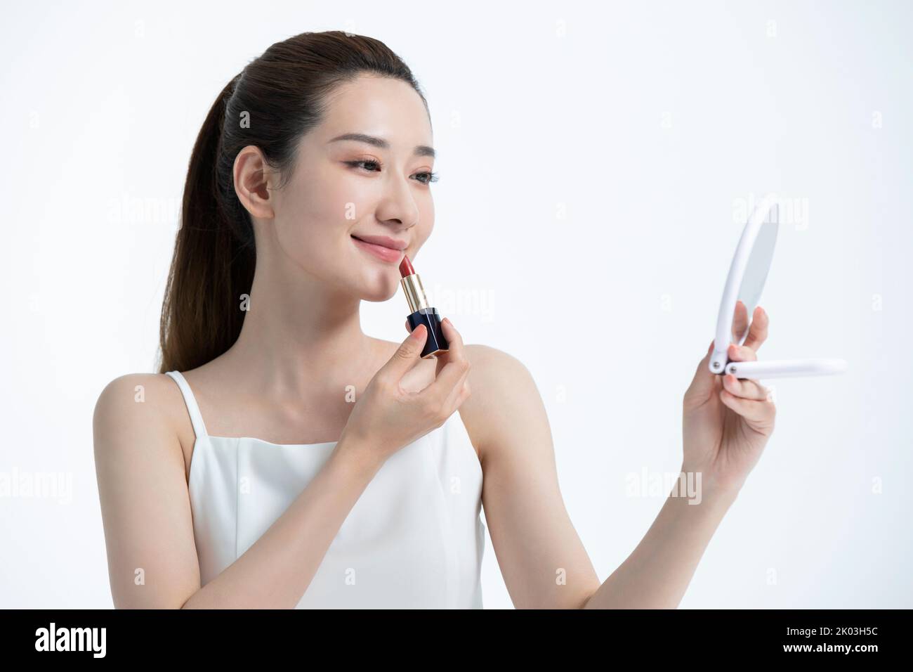 Schöne junge chinesische Frau, die Make-up anwendet Stockfoto