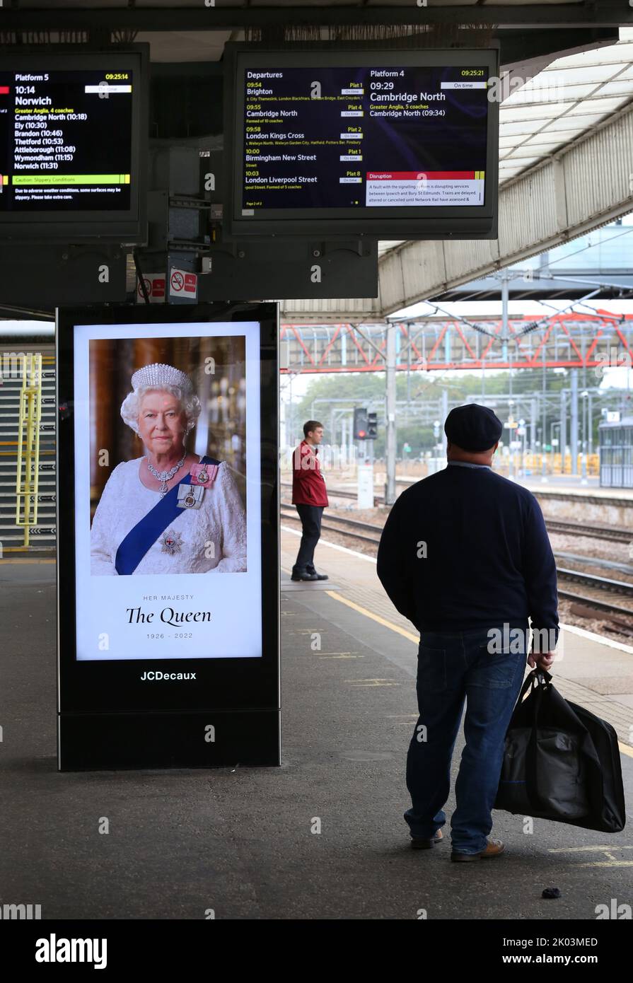 London, Großbritannien. 09. September 2022. Reisende auf dem Bahnsteig des Bahnhofs Cambridge teilen sich den Bahnsteig mit einem großen Porträt, das vom Tod Ihrer Majestät Königin Elizabeth II. Erzählt Ihre Majestät Königin Elizabeth II. Ist im Alter von 96 Jahren in Balmoral Castle gestorben, nachdem sie 70 Jahre lang über das Vereinigte Königreich regiert hat. (Foto von Martin Pope/SOPA Images/Sipa USA) Quelle: SIPA USA/Alamy Live News Stockfoto