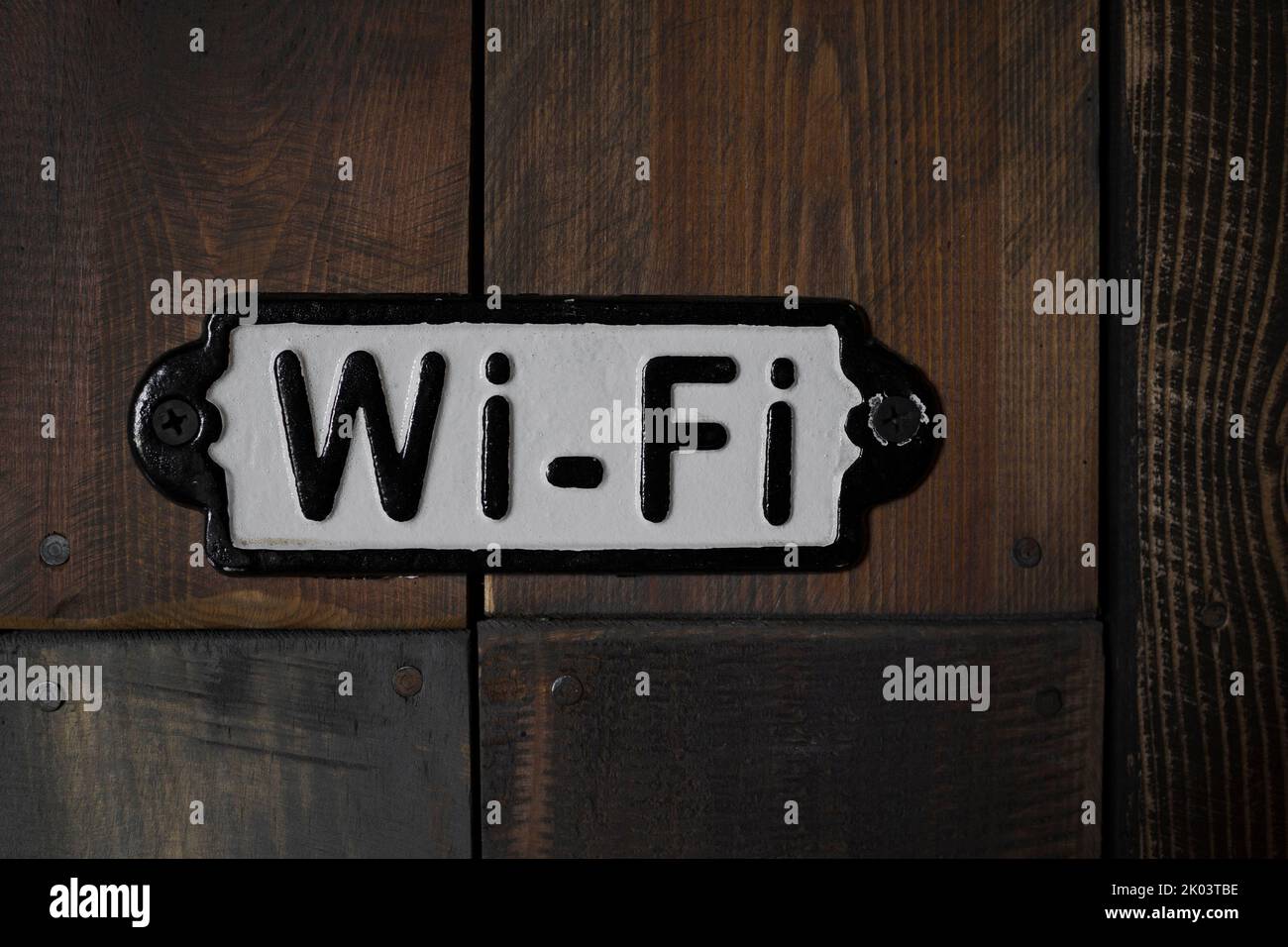 Metallplatte mit wi-Fi-Schild an der alten Holzwand Stockfoto