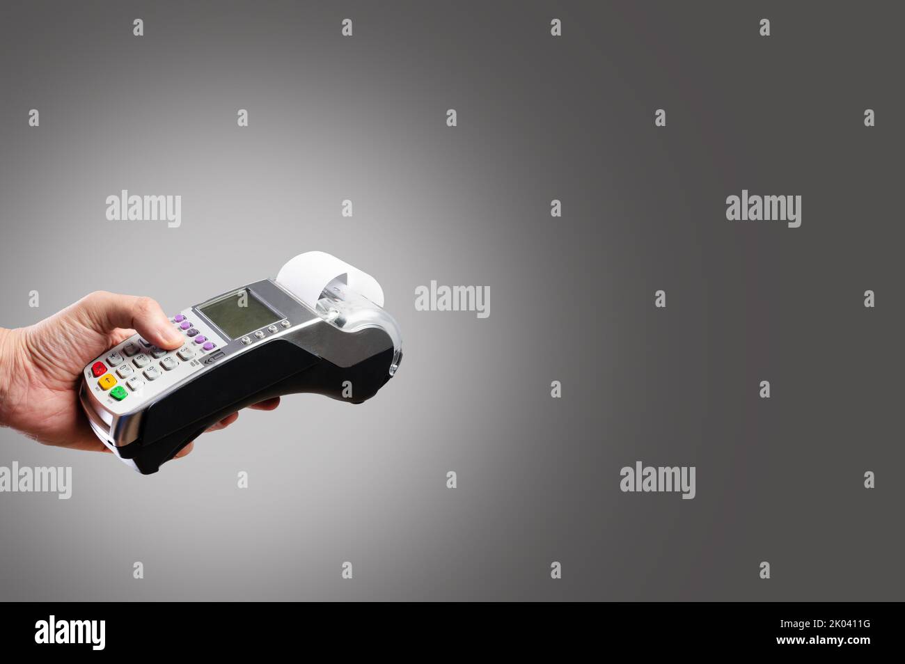 Geldautomaten in weiblicher Hand auf grauem Hintergrund. Groß- und Einzelhandel, Käufe, Verkäufe, Bankkarten, Darlehen. Minimalismus. Es ist freier Speicherplatz vorhanden Stockfoto