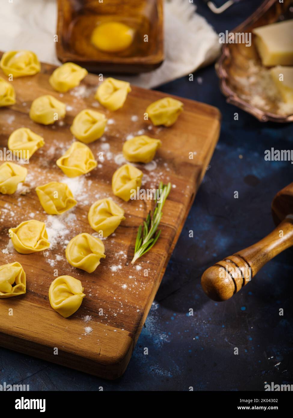 Rohe hausgemachte, handgemachte Knödel auf einem bemehlten Schneidebrett auf blauem Marmorboden. Rezepte zum Kochen von Gerichten mit Hackfleisch. Familientraditionen Stockfoto