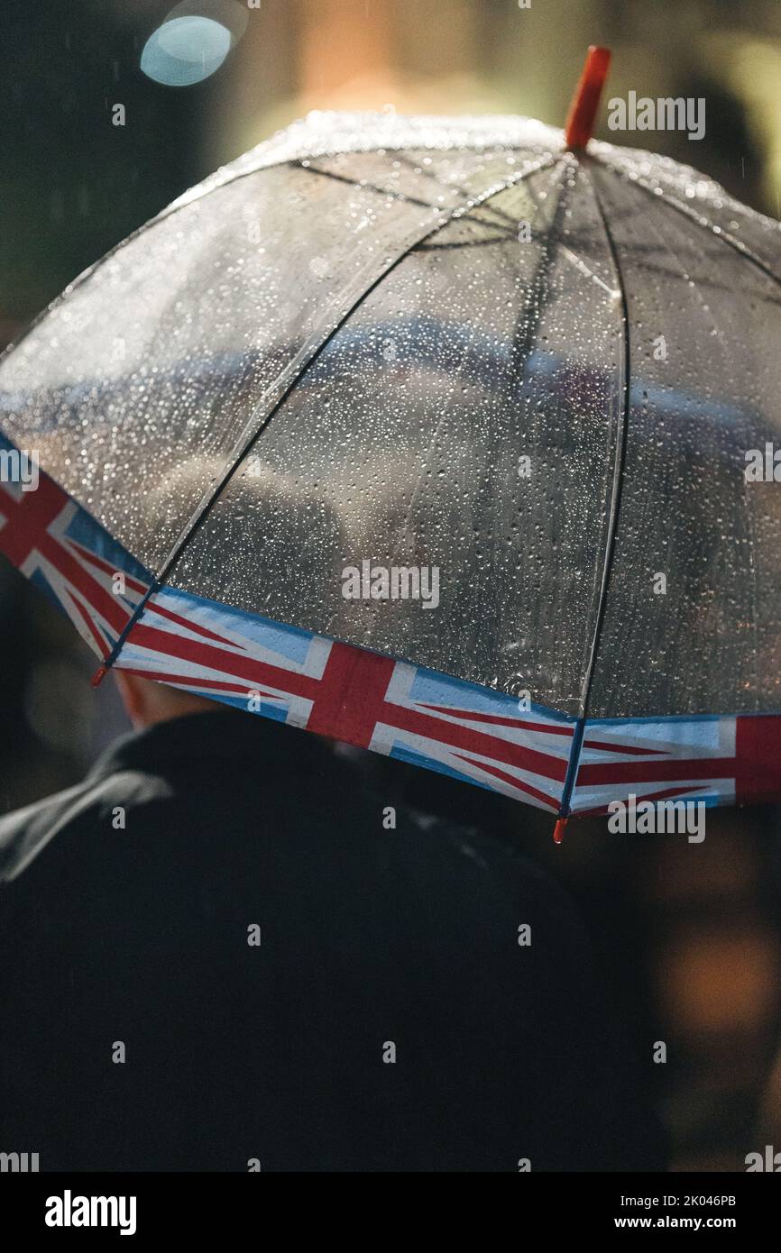 London | UK - 2022.09.08: Menschen trauern und bringen Blumen unter dem Regen vor den Buckingham Palace, nachdem Königin Elizabeth gestorben ist Stockfoto