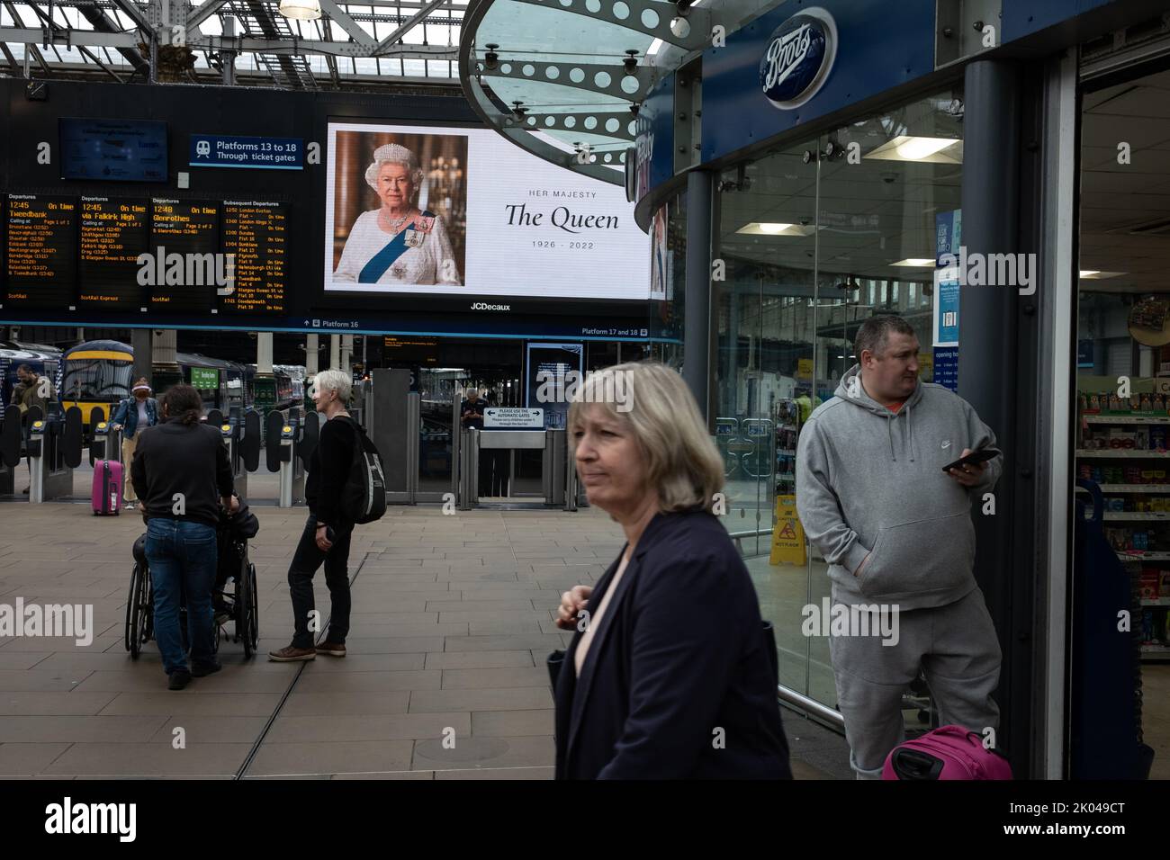 Edinburgh, Schottland, 9. September 2022. Pendler kommen an einem Digitaldisplay vorbei, auf dem ein Porträt ihrer Majestät Königin Elizabeth II., die im Alter von 96 Jahren gestorben ist, in der Waverley Station in Edinburgh, Schottland, am 9. September 2022 zu sehen ist. Bildnachweis: Jeremy Sutton-Hibbert/ Alamy Live Nachrichten. Stockfoto