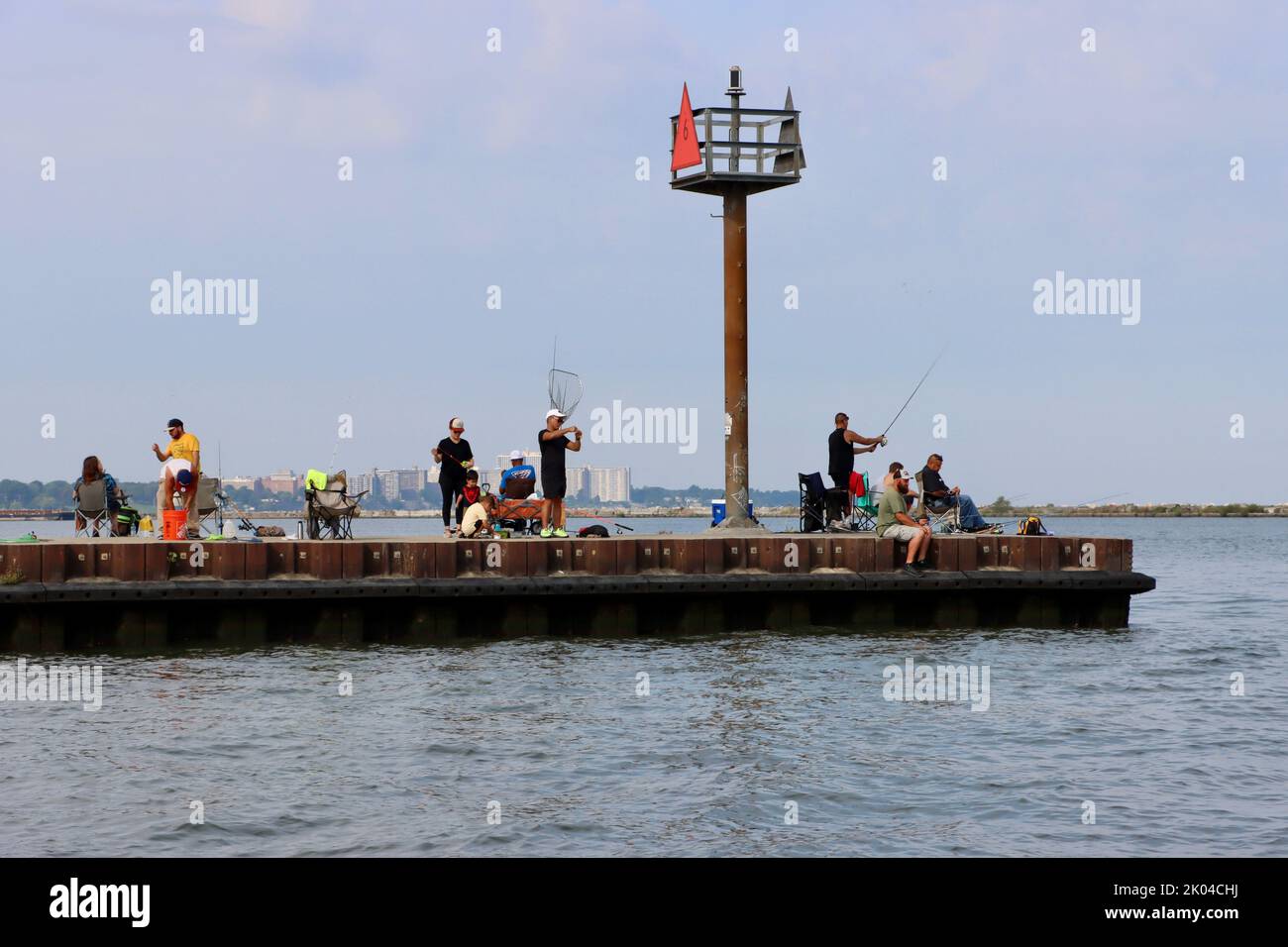 Fischer am Pier, die von der historischen Küstenwache im Hafen von Cleveland ausgehen Stockfoto