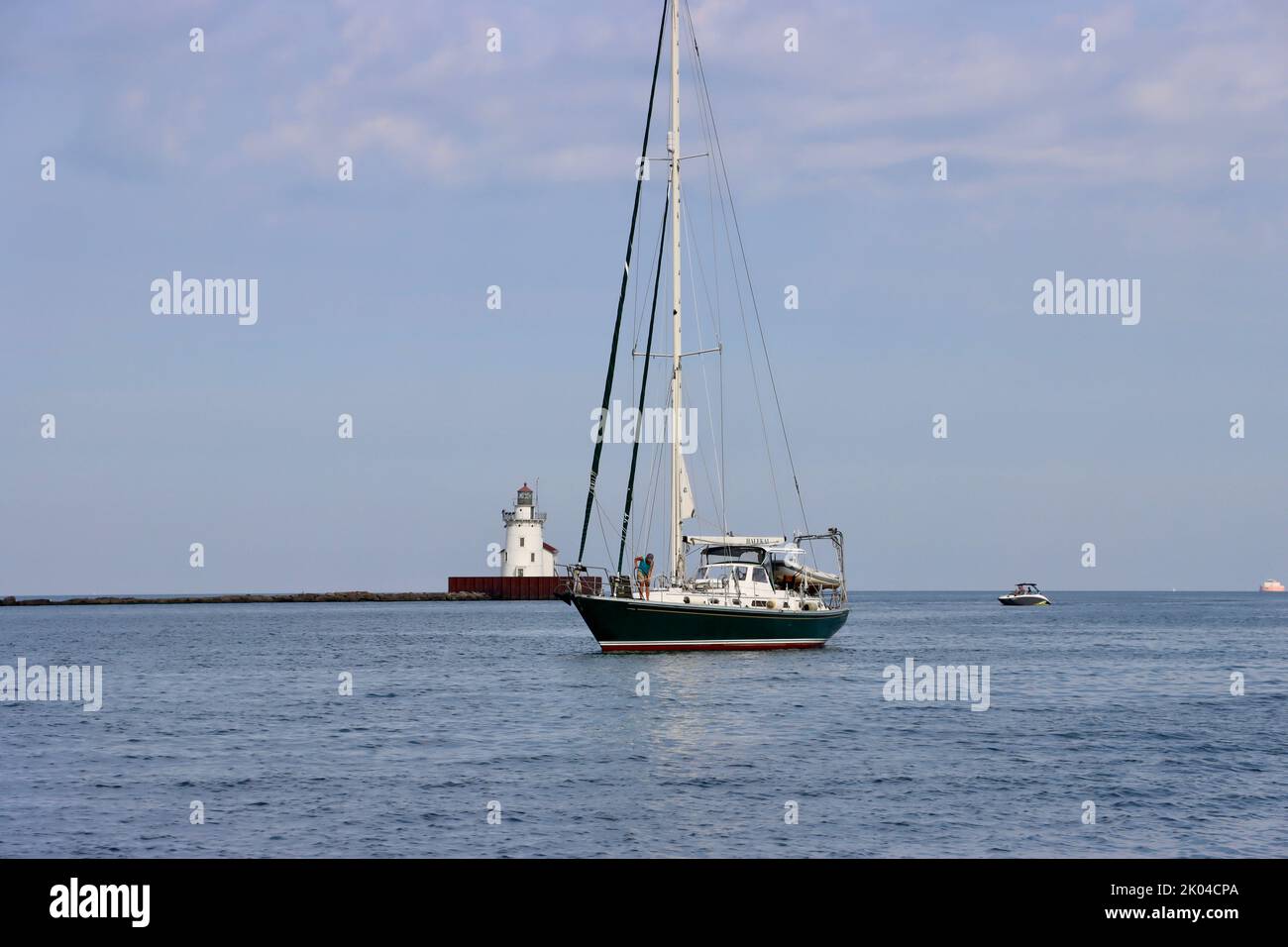 Ein Schwanenboot, das am West Pierhead Lighthouse am Hafen von Cleveland vorbeifährt. Stockfoto