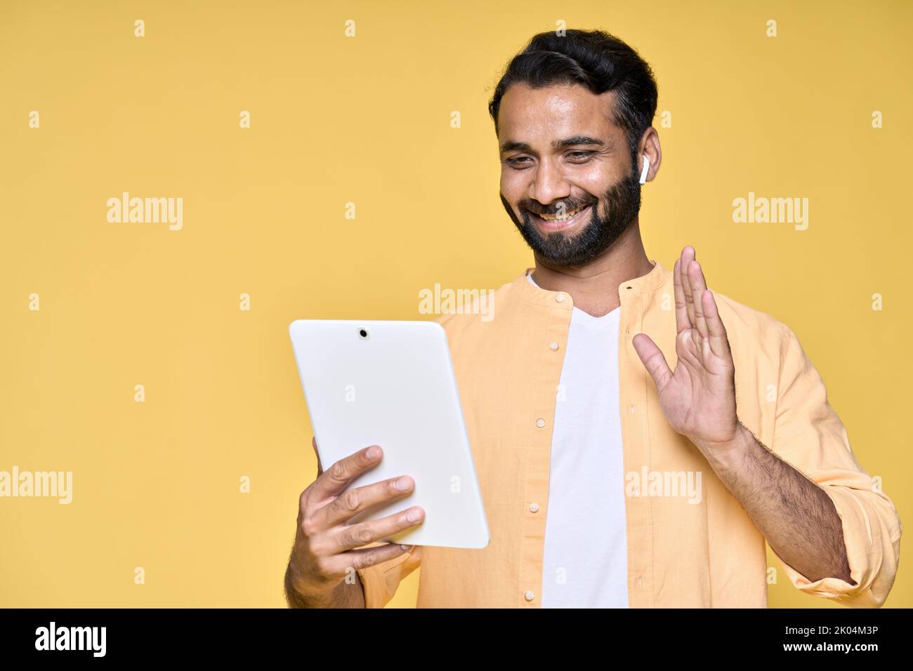 Happy indian Mann Video-Anruf auf digitalen Tablet isoliert auf gelbem Hintergrund. Stockfoto
