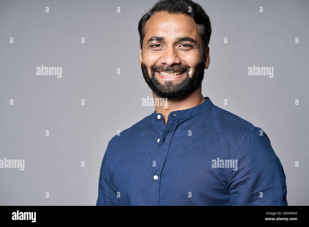 Lächelnder indischer Geschäftsmann, isoliert auf grauem Kopfbild. Stockfoto