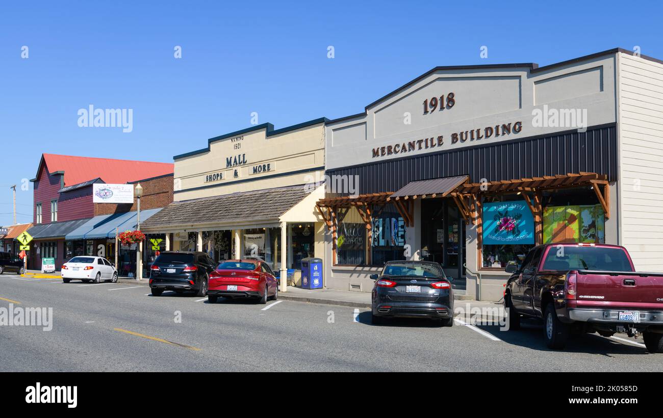 Stanwood, WA, USA - 11. August 2022; Alte Gebäude in der Innenstadt von Stanwood Washington mit Autos schräg vor den Geschäften geparkt Stockfoto