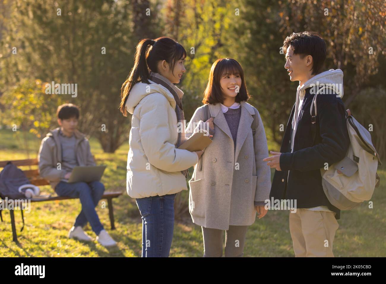 Glückliche chinesische Studenten sprechen auf dem Campus Stockfoto