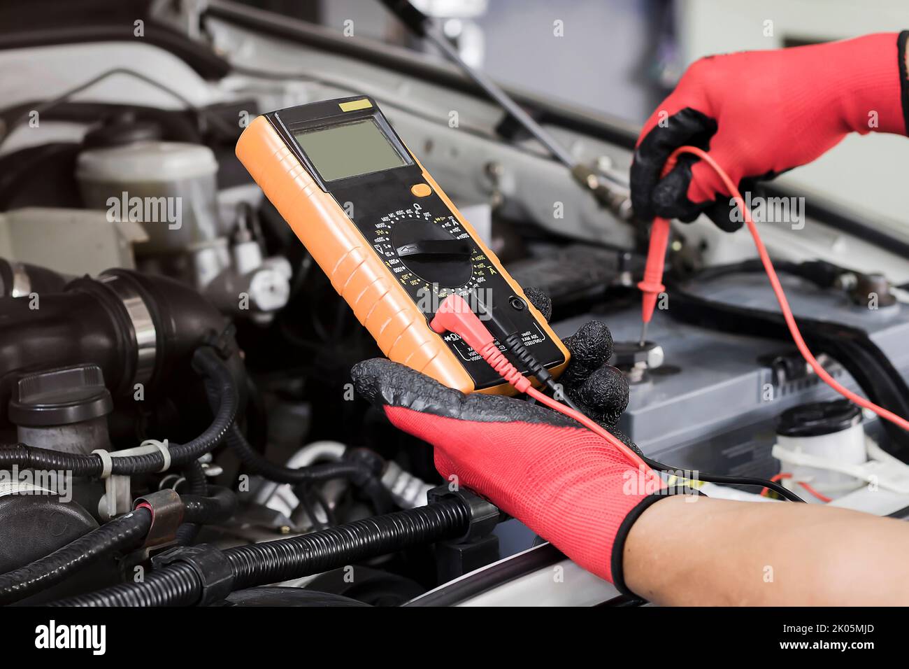 Ein Techniker überprüft die Fahrzeugbatterie auf Verfügbarkeit. Stockfoto