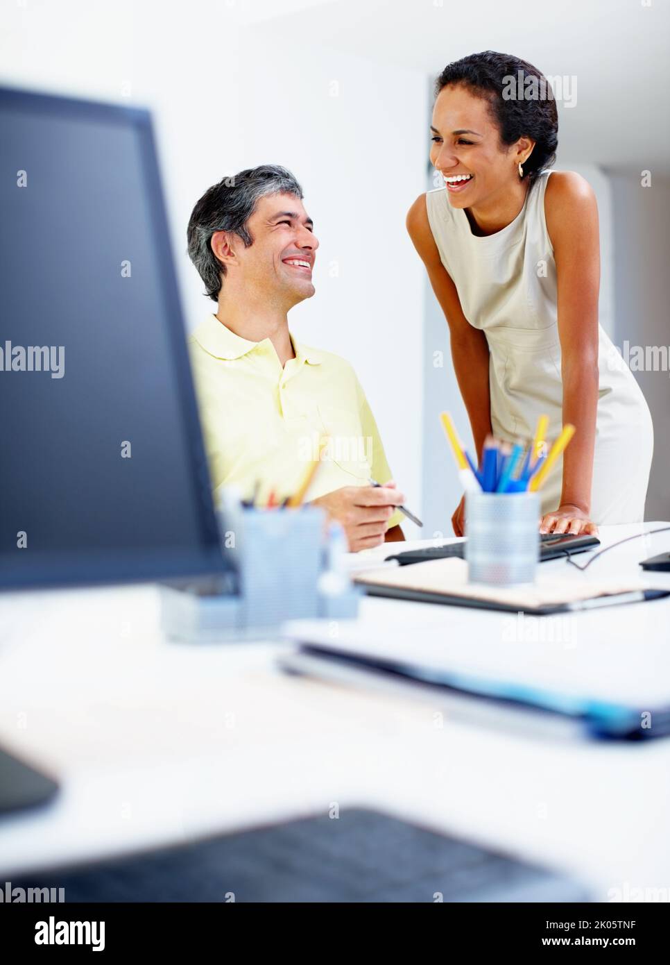 Führungskräfte arbeiten gerne. Zwei zwanglos gekleidete Geschäftsleute genießen ihre Arbeit. Stockfoto