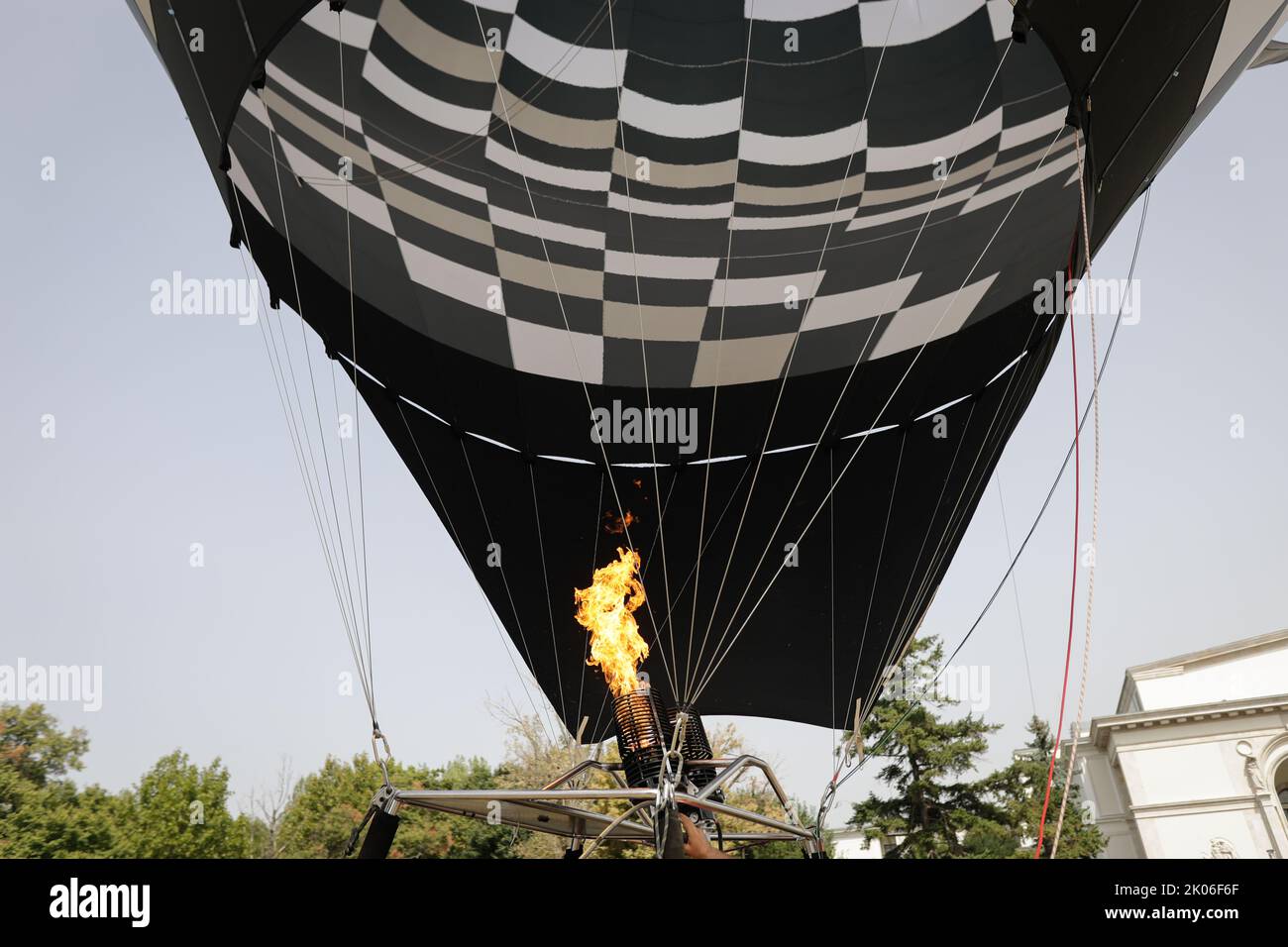 Bukarest, Rumänien - 27. August 2022: Ein Mann benutzt einen doppelten Gasbrenner, um einen Heißluftballon aufzublasen. Stockfoto