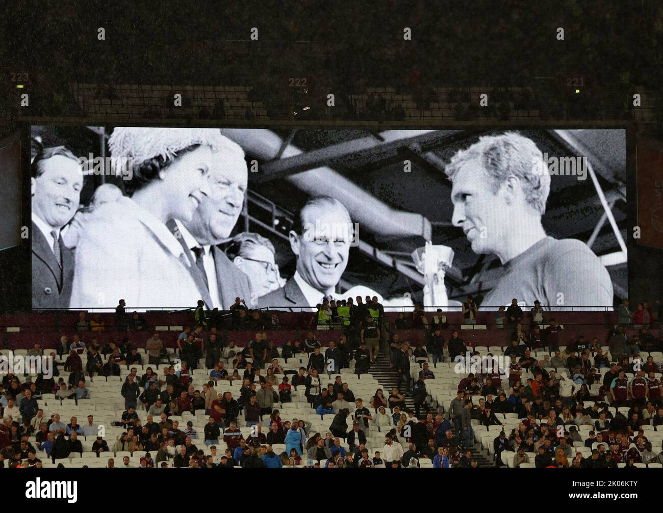 London, Großbritannien. 8.. September 2022. Europa Conference League: West Ham United / Steaua Bucharest, London Stadium, London, UK. Ein Foto von Queen Elizabeth II, die dem britischen Kapitän Bobby Moore die WM-Trophäe 1966 überreicht hat, während der Halbzeit der Ehemann Prinz Philip auf der Leinwand zu sehen ist.Quelle: Michael Zemanek/Alamy Live News Stockfoto