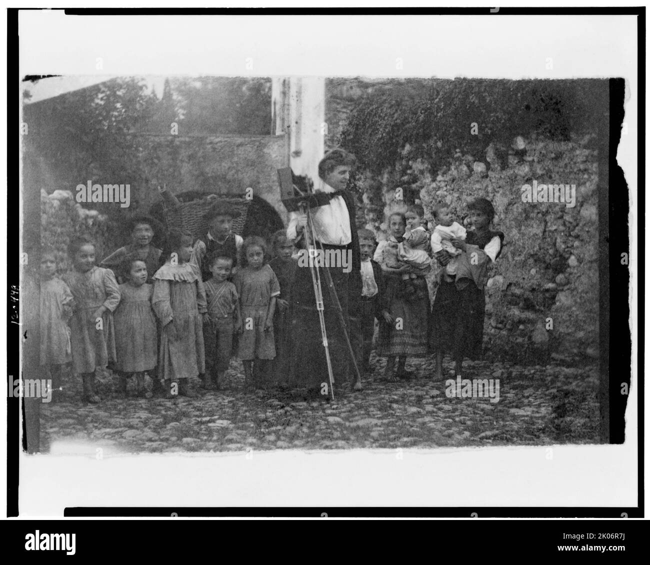 Miss Johnston &amp; Audience, Comer See, Italien, 1899. [Fotografin] Frances Benjamin Johnston, stehend mit ihrer Kamera, und eine Gruppe von Kindern. Stockfoto