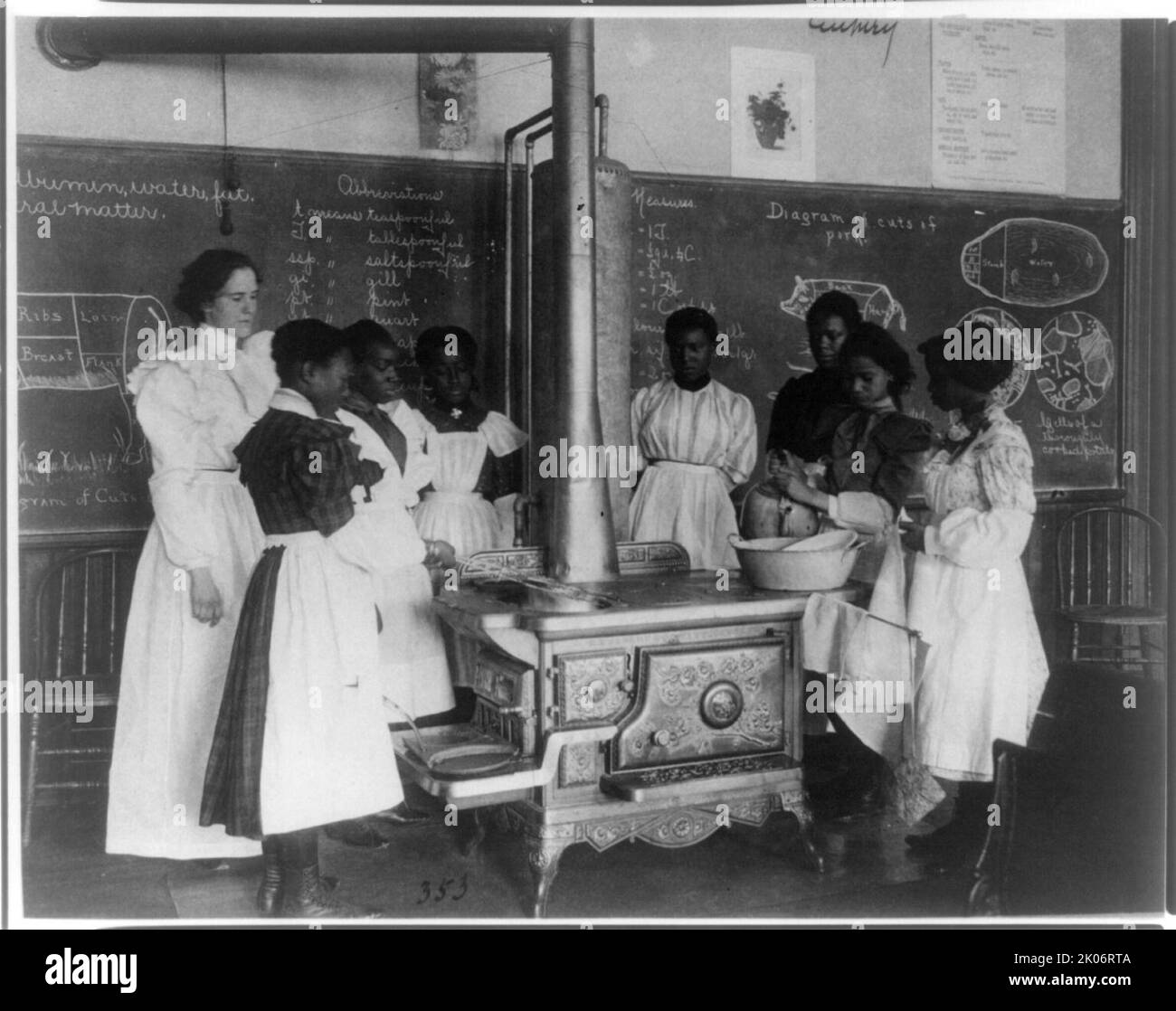 Afroamerikanische Schülerinnen mit Lehrer, lernen auf einem Holzofen im Klassenzimmer zu kochen, (1899?). Stockfoto