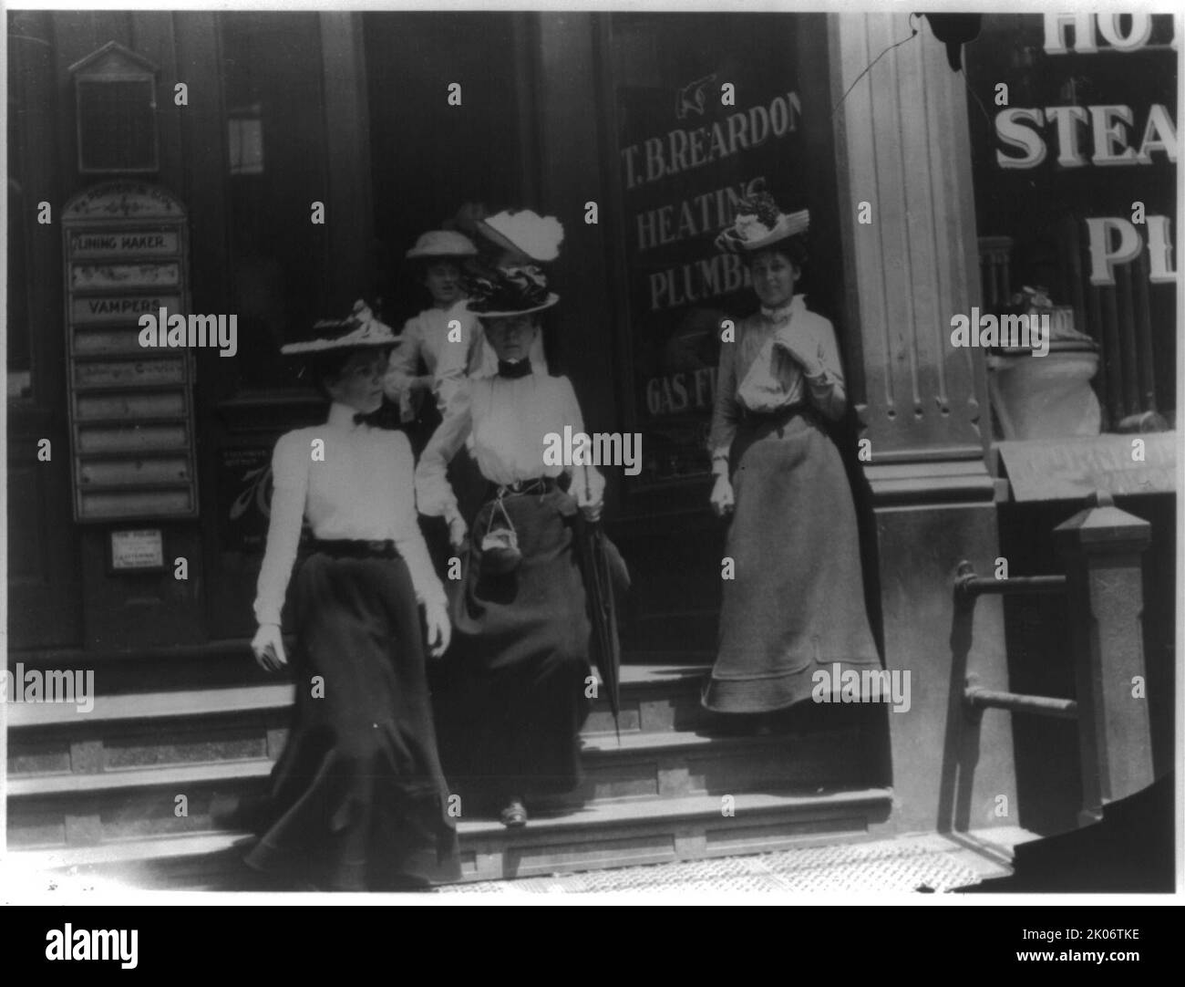 Frauen, die von der Arbeit kommen, Kal.?. Im Schaufenster wird T.B. angezeigt Reardon, Heizung und Sanitär, 1903. Foto zeigt vier Frauen, die den Fernseher verlassen Reardon, Heizung und Sanitär Gebäude. Frances Benjamin Johnston Collection. Stockfoto