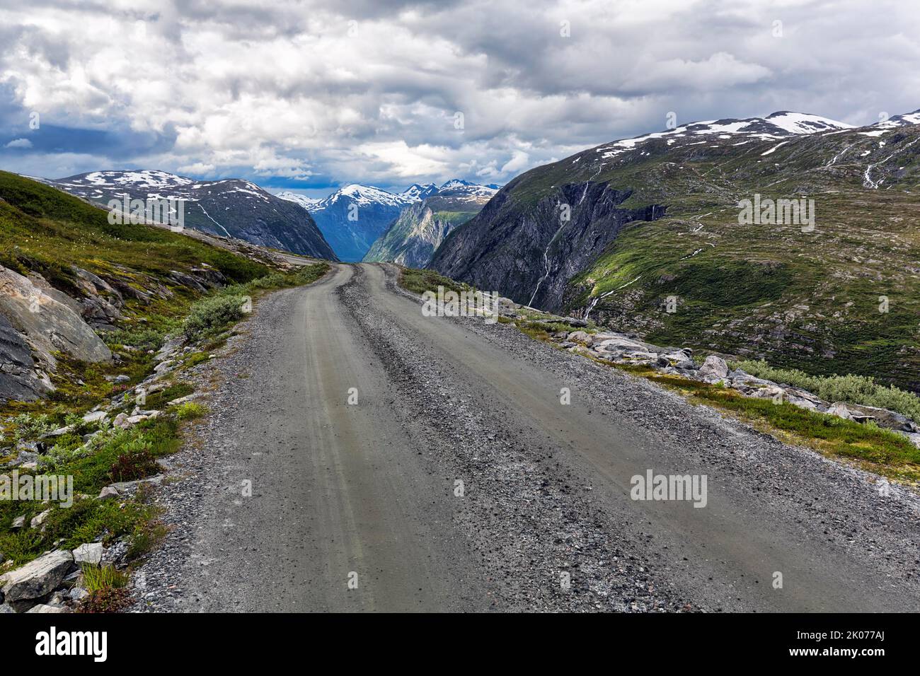 Schotterstraße durch karge Berglandschaft mit Schneeresten, beeindruckende Landschaftsroute Aursjovegen, Aursjovegen, Dovrefjell-Sunndalsfjella Stockfoto