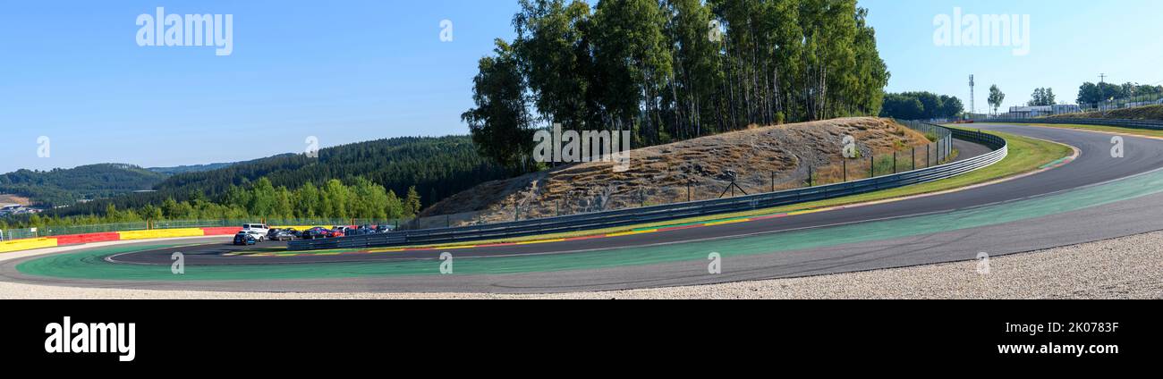 Panoramafoto der steil abfallenden Kurve 8 des Circuit de Spa Francorchamps, im linken Hintergrund private Autos der Teilnehmer des Trackday während Stockfoto