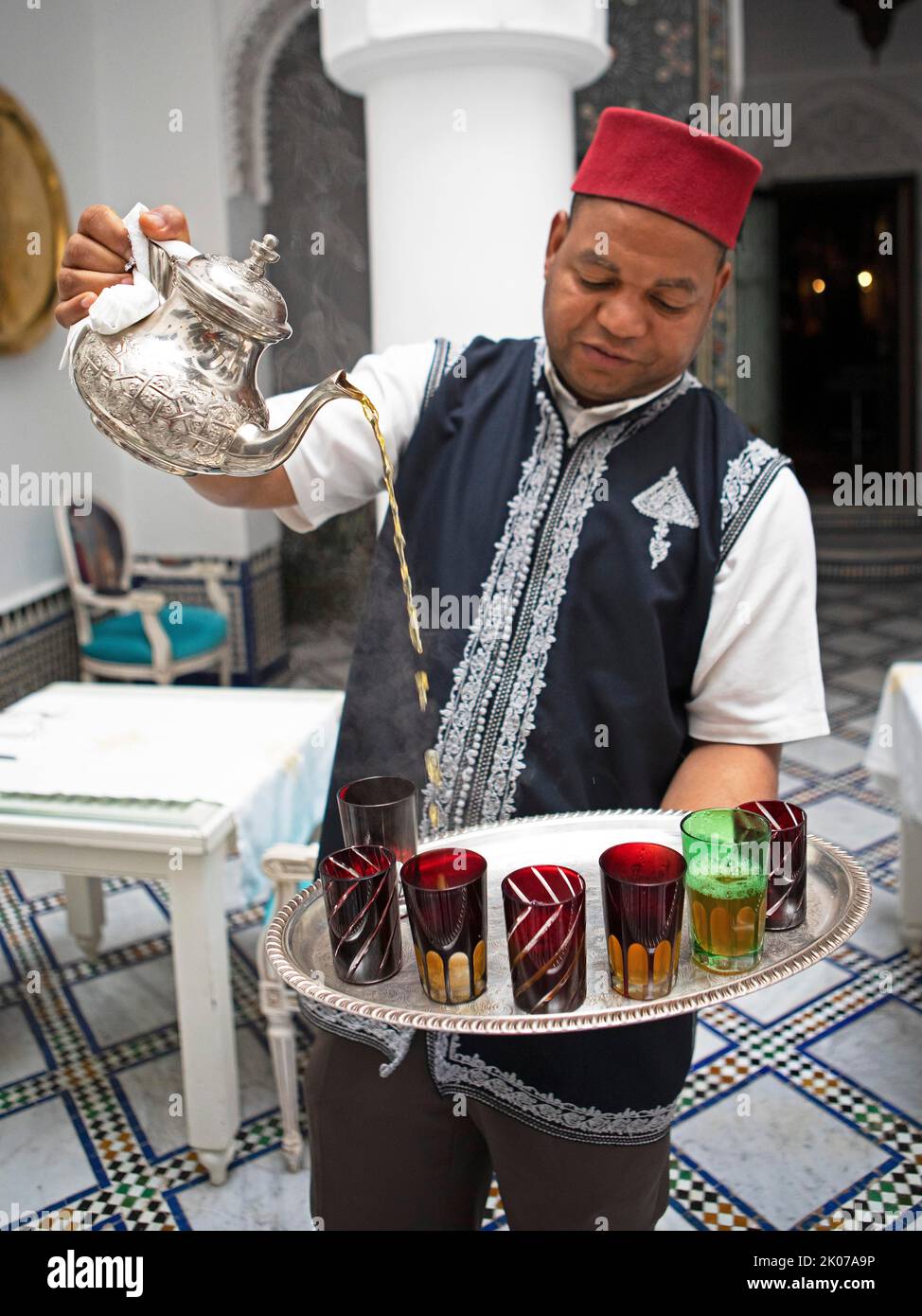 Mann, der Tee in ein Glas gießt, Fes, Marokko Stockfoto