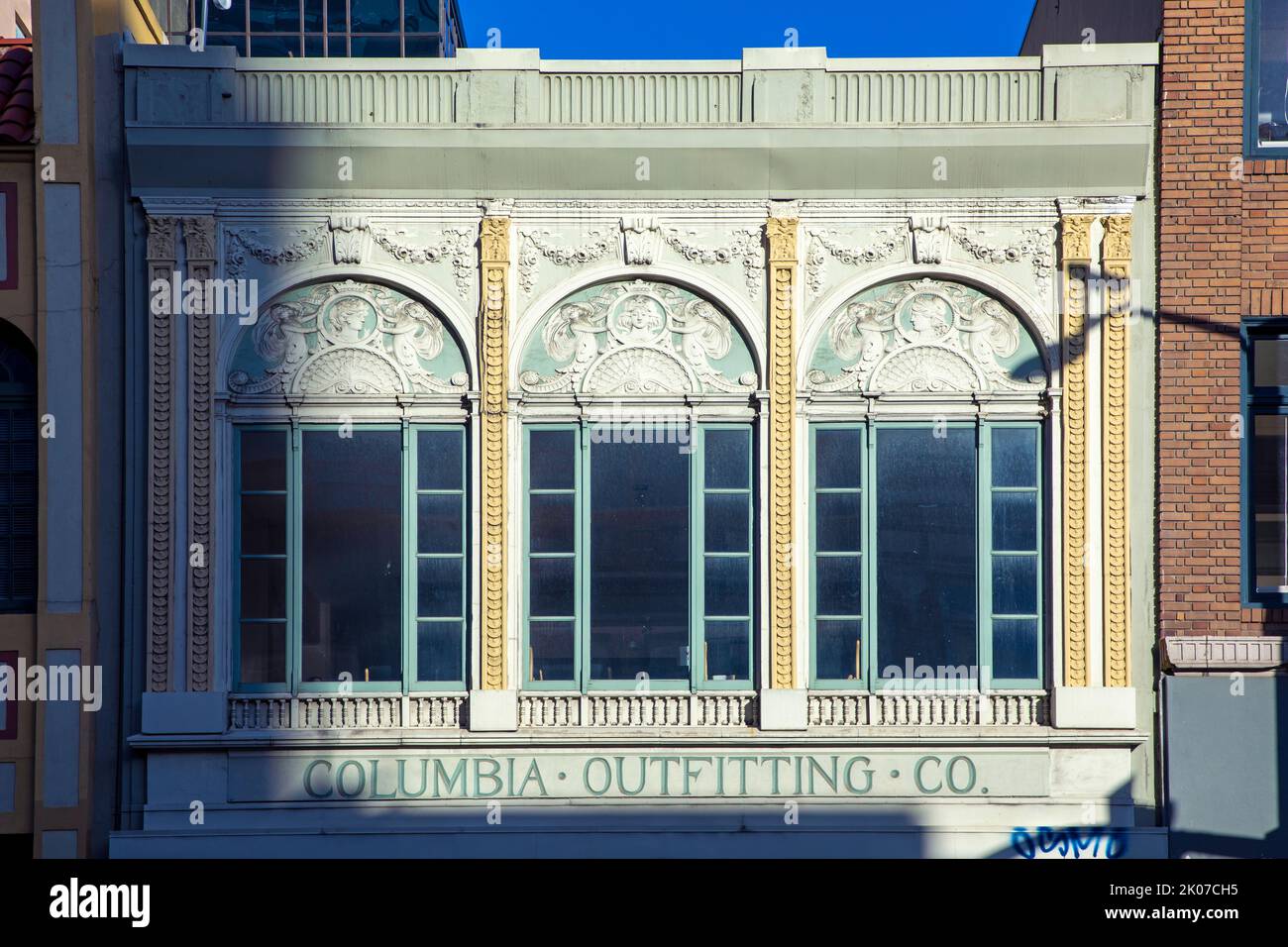 Oakland, USA - 19. Mai 2022: Die Morgensonne geht auf der Straße 17. mit Blick auf die Fassade der Columbia Outfitting Company in der Innenstadt von Oakland auf. Stockfoto