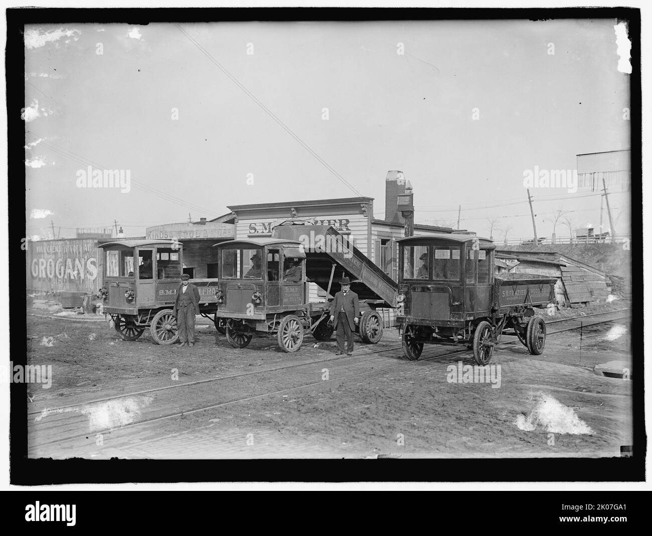 Drei LKW: S.M. Frazier, zwischen 1909 und 1914. USA. „Ihr Kredit ist gut bei Grogan“. „S. M. Frazier, Building Materials, Anacostia, [Washington] D.C.“ Stockfoto