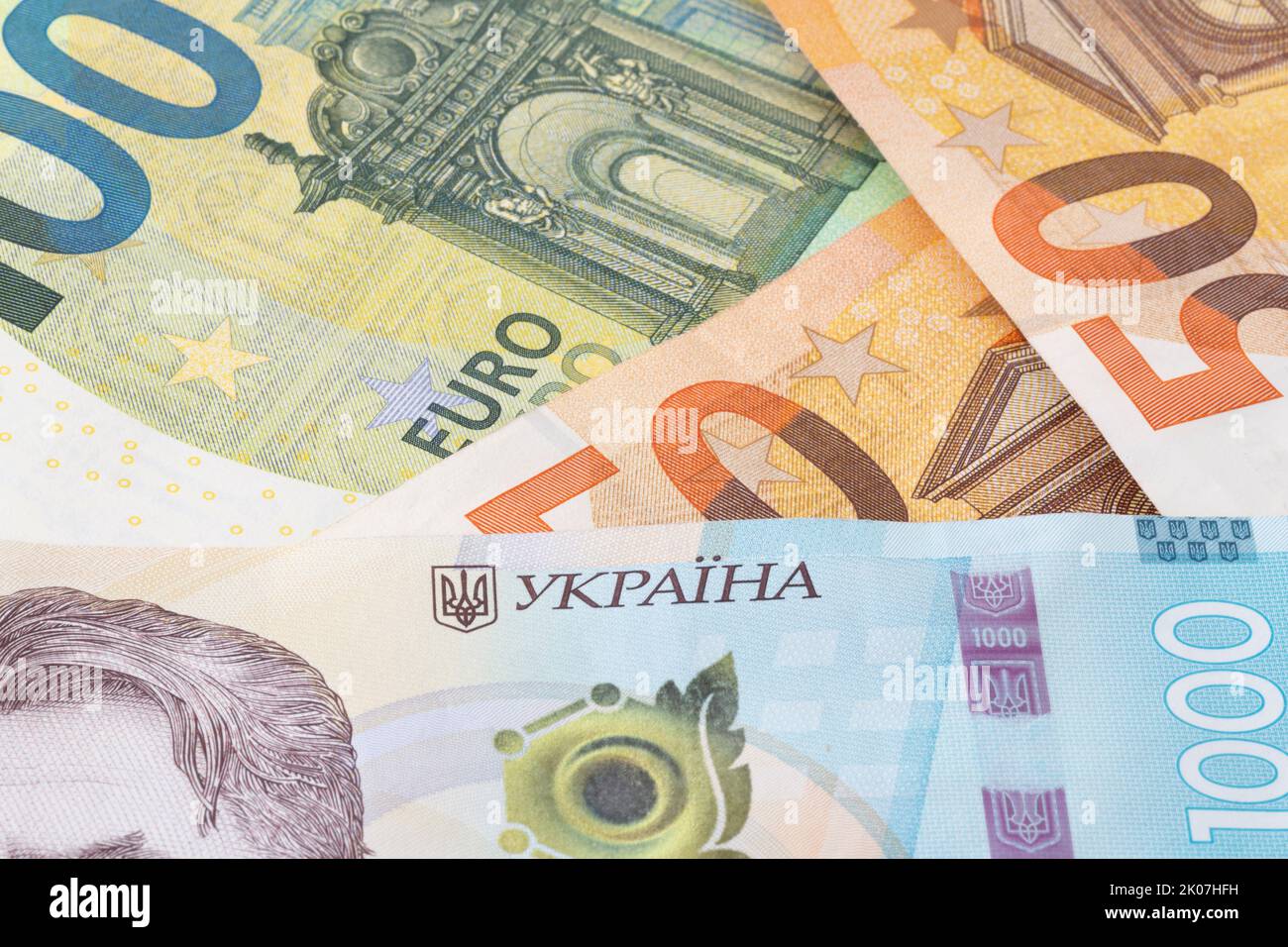 Nahaufnahme von tausend ukrainischen hrivnya-Banknoten gegen mehrere Euro-Banknoten Stockfoto