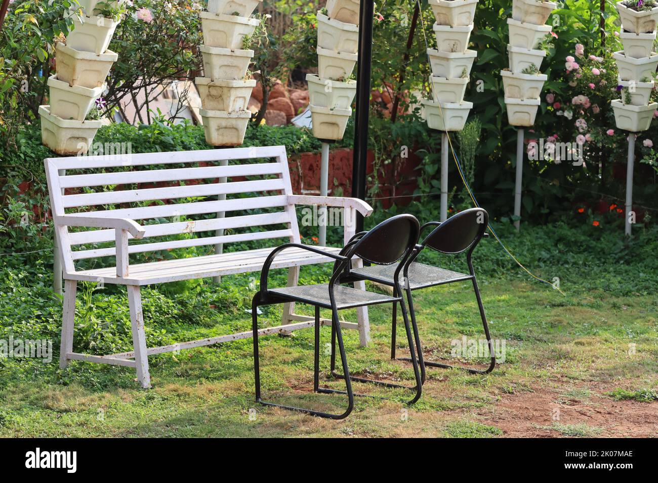 Leere Bank und Stuhl aus dem Garten ein ruhiger Ort für die Arbeit von zu Hause aus Stockfoto