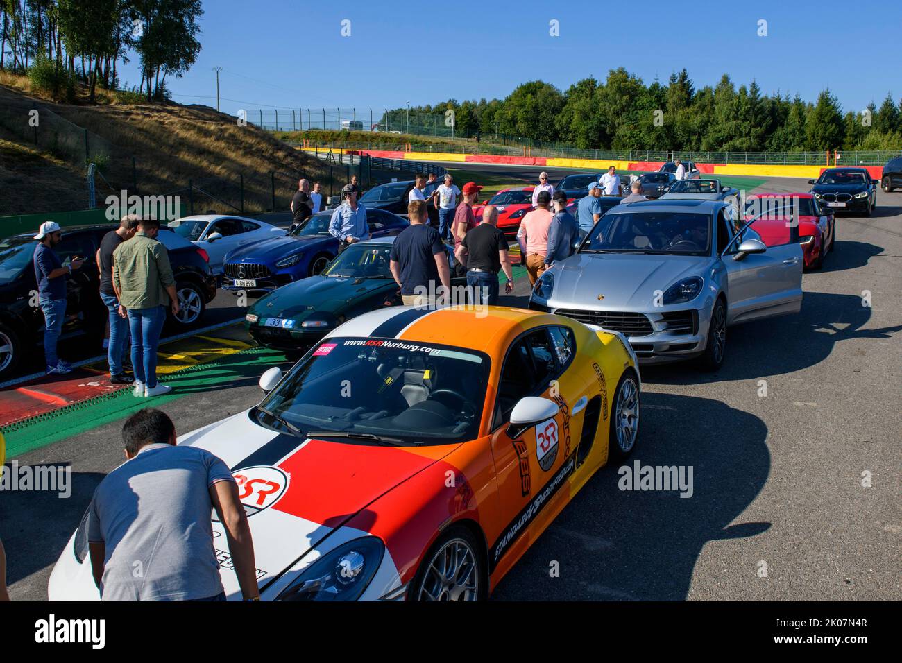 Geparkte Autos der Teilnehmer von Trackday während der Streckenbesichtigung der Rennstrecke für Motorsportwagenrennen, im Vordergrund Porsche 911, dahinter Stockfoto