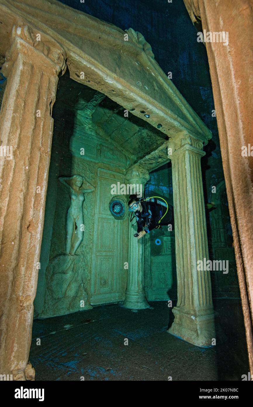 Taucher taucht durch stilisierte Ruine des Portaleingangs des alten Tempels in 20 Metern Wassertiefe im Indoor-Tauchturm, im Vordergrund nachgebildet Stockfoto