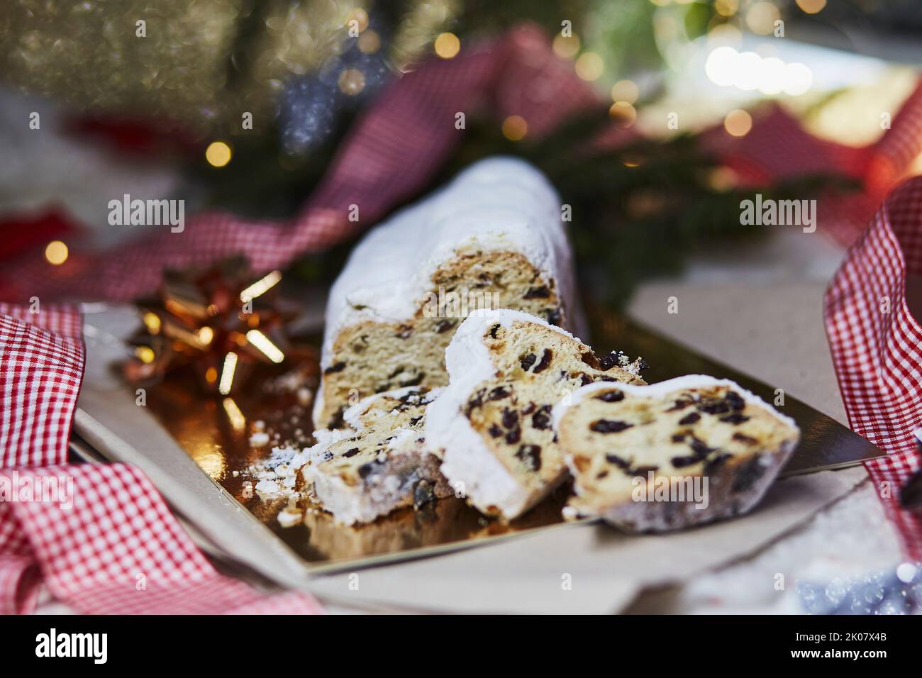 Weihnachtsstollen auf Reflektionspapier Hintergrund. Traditionelles weihnachtliches festliches Gebäck Dessert. Weihnachtstradition mit Bokeh Hintergrund. Festlicher Bac Stockfoto