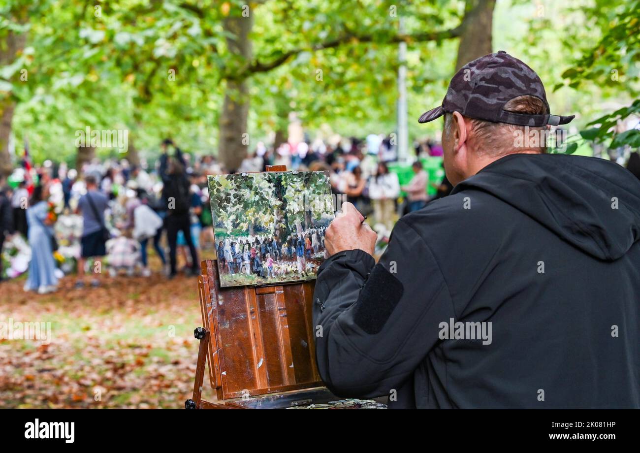 London UK 10. September 2022 - eine Künstlerin malt die Szene, während Menschenmengen ihren Respekt zollen und weiterhin Blumen in den Green Park in London bringen, als Hommage an Königin Elizabeth II., nachdem ihr Tod am vergangenen Donnerstag bekannt gegeben wurde. Die Blumen wurden am Tag, an dem König Charles III. Auch zum Monarchen ernannt wurde, von außerhalb des Buckingham Palace verschoben : Credit Simon Dack / Alamy Live News Stockfoto