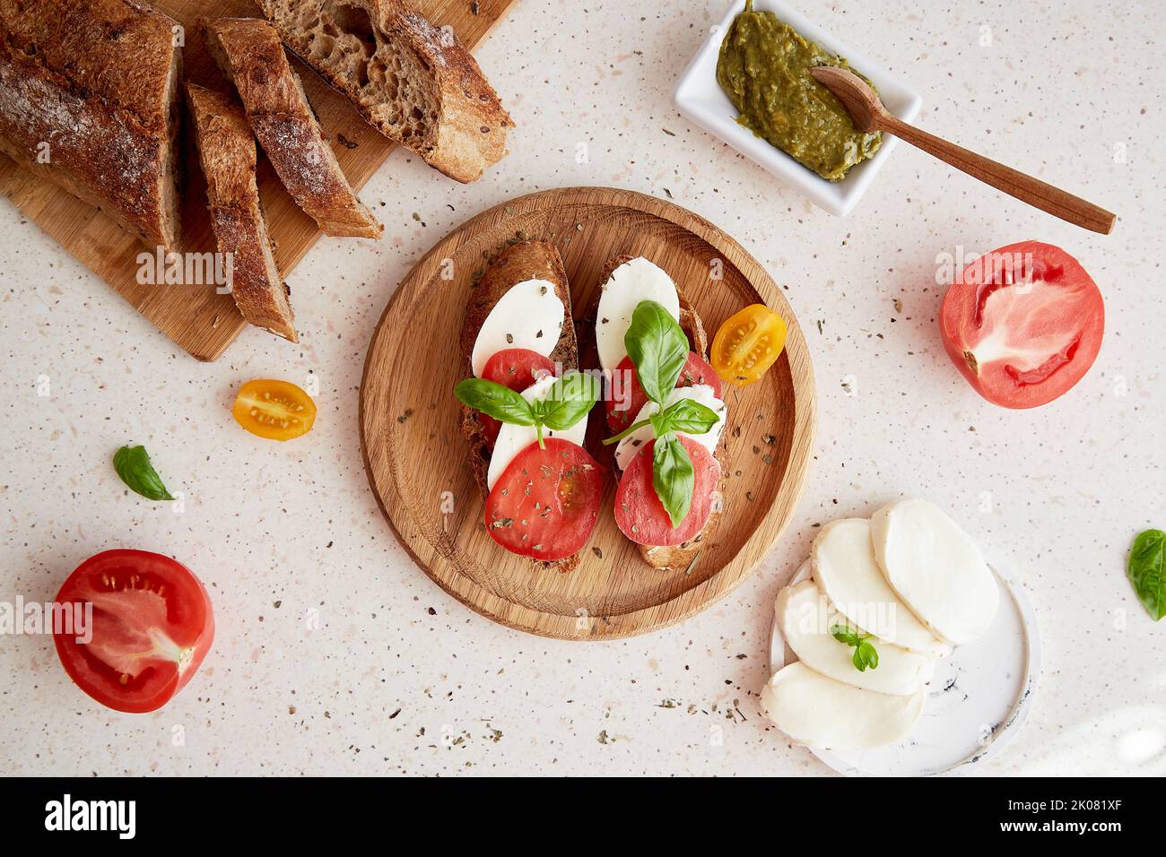 Hausgemachtes Caprese Sandwich Italienische Vorspeise, Snack mit frischen Mozzarella, Tomaten, Basilikumblättern und Pesto-Sauce mit Brot. Mediterrane klassische Recip Stockfoto