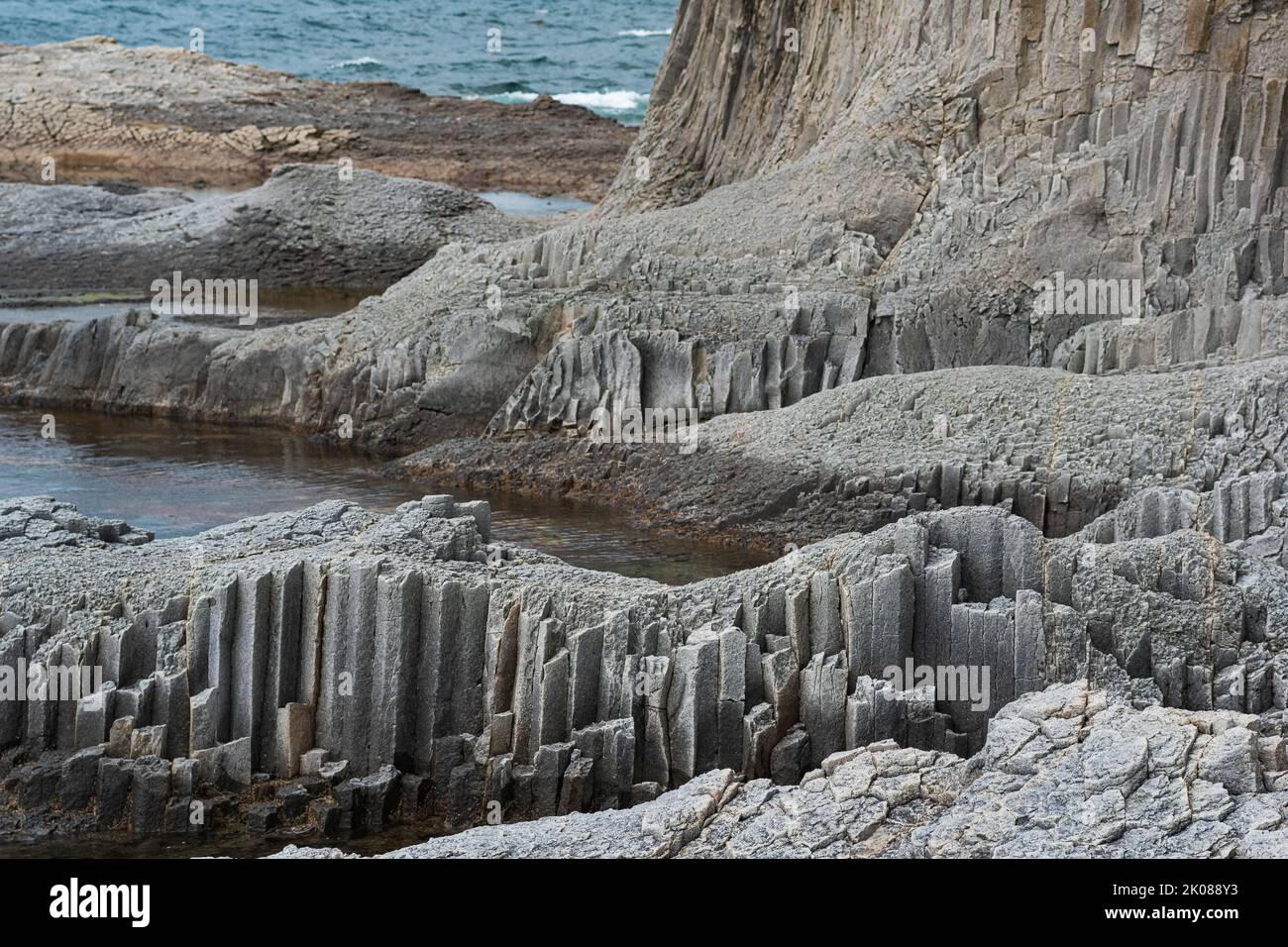 Küstenlandschaft mit wunderschönen säulenförmigen Basaltklippen bei Ebbe Stockfoto
