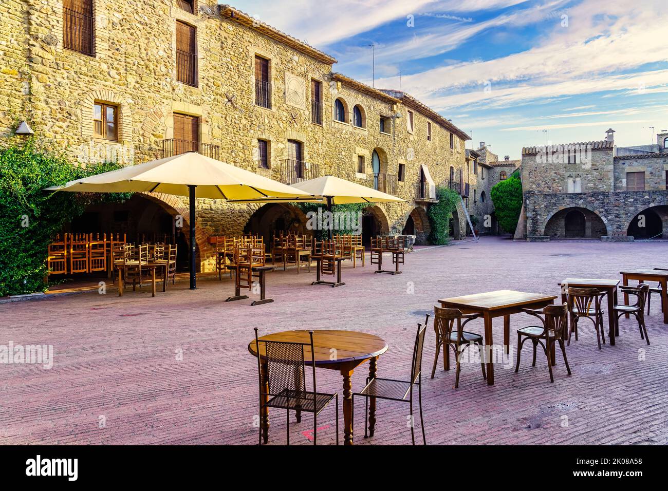 Zentraler Platz des mittelalterlichen Dorfes Monells mit seinen Steinhäusern und Bögen in den Gebäuden, Girona, Spanien. Stockfoto