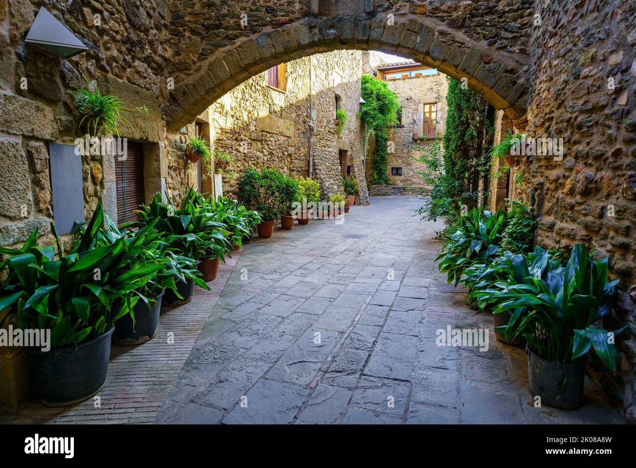 Durchgänge mit Steinarkaden und mittelalterlichen Häusern in einem malerischen Stil und von großer Schönheit, Monells, Girona, Katalonien. Stockfoto