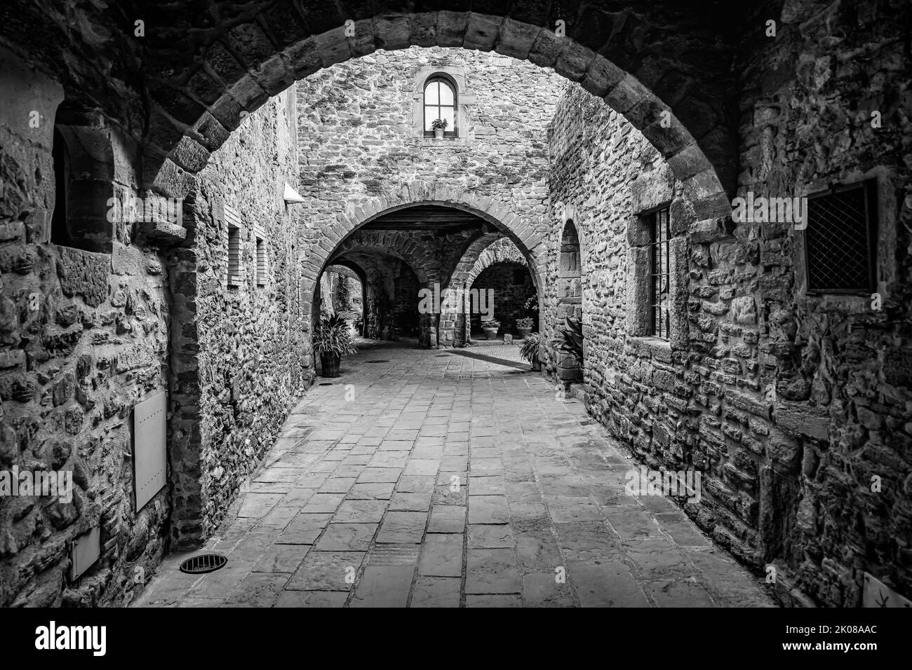 Durchgänge mit Steinarkaden und mittelalterlichen Häusern in einem malerischen Stil und von großer Schönheit, Monells, Girona, Katalonien. Stockfoto